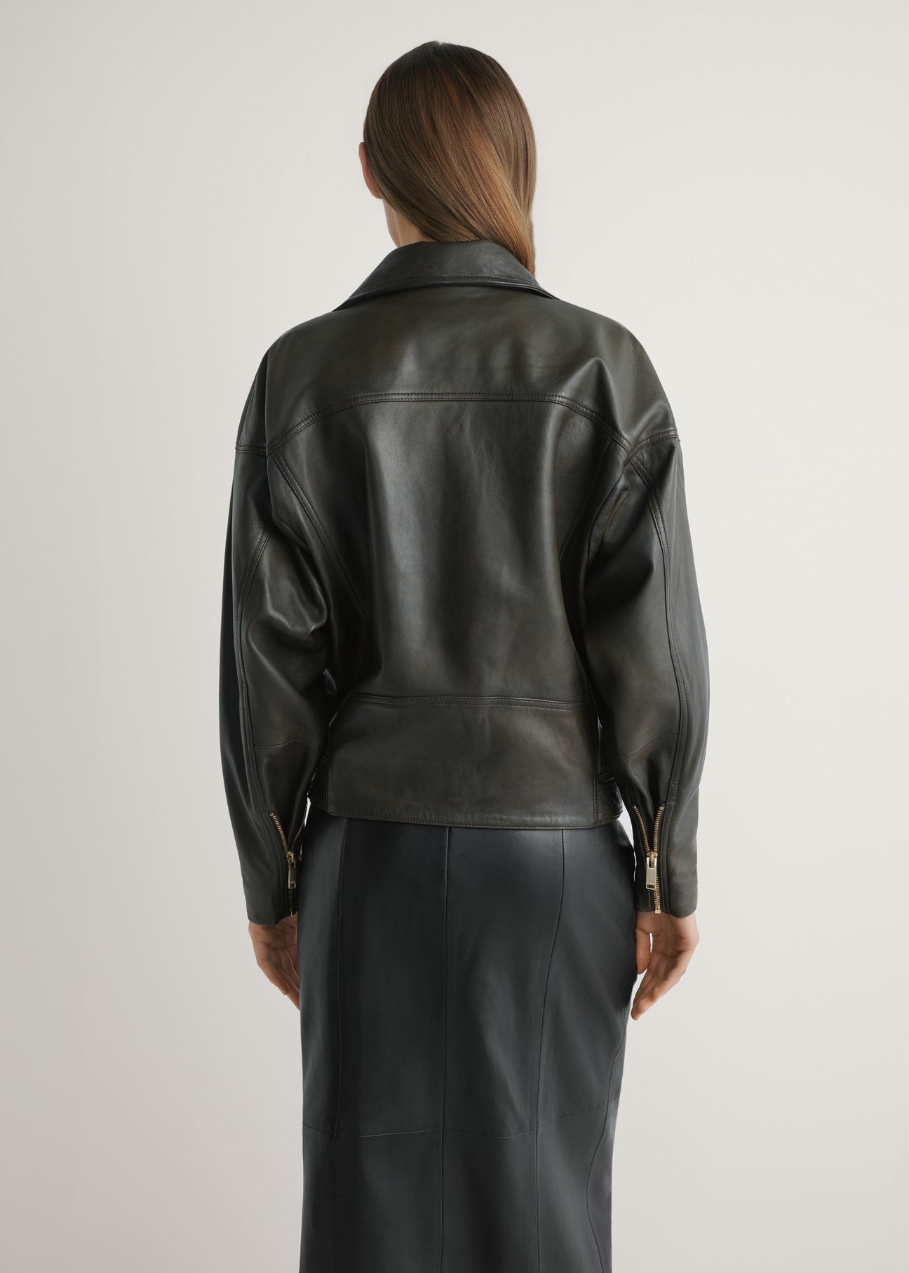 Women's oversize brown leather biker jacket KURDS-0608-1I(W26), back view of the product on the model. Half of the silhouette visible.