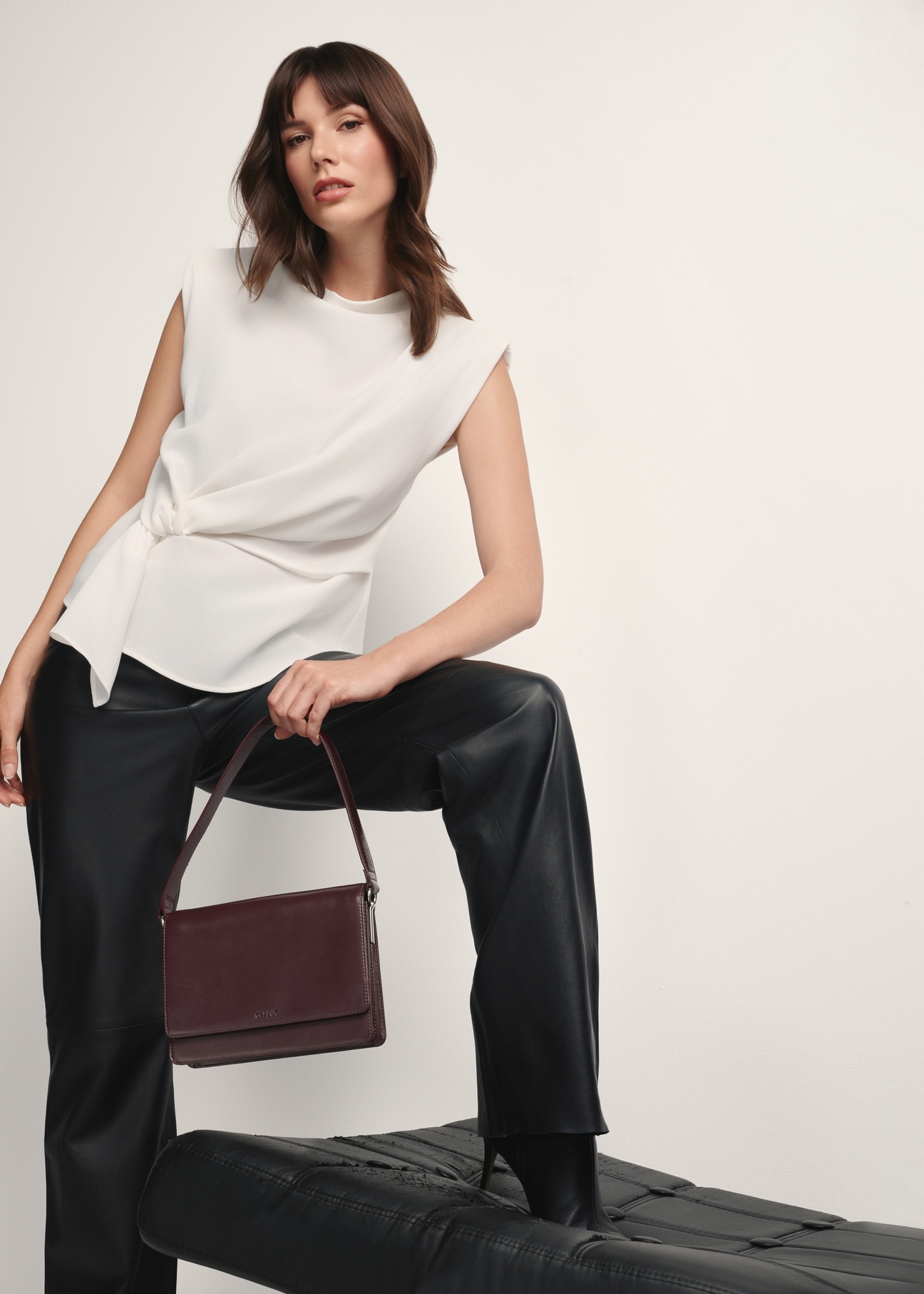 Women's leather handbag in burgundy color TORES-1189-49(Z25), view of the product in the model's hand on a light background.