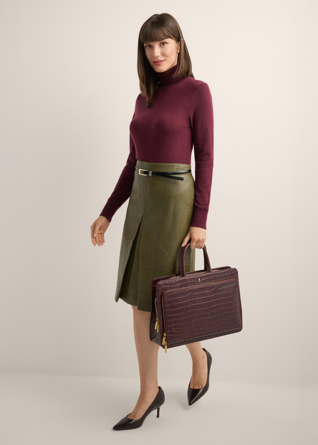Burgundy croco leather laptop bag TORES-1321-4D(Z26), front view of the product in the model's hand, on a light background.