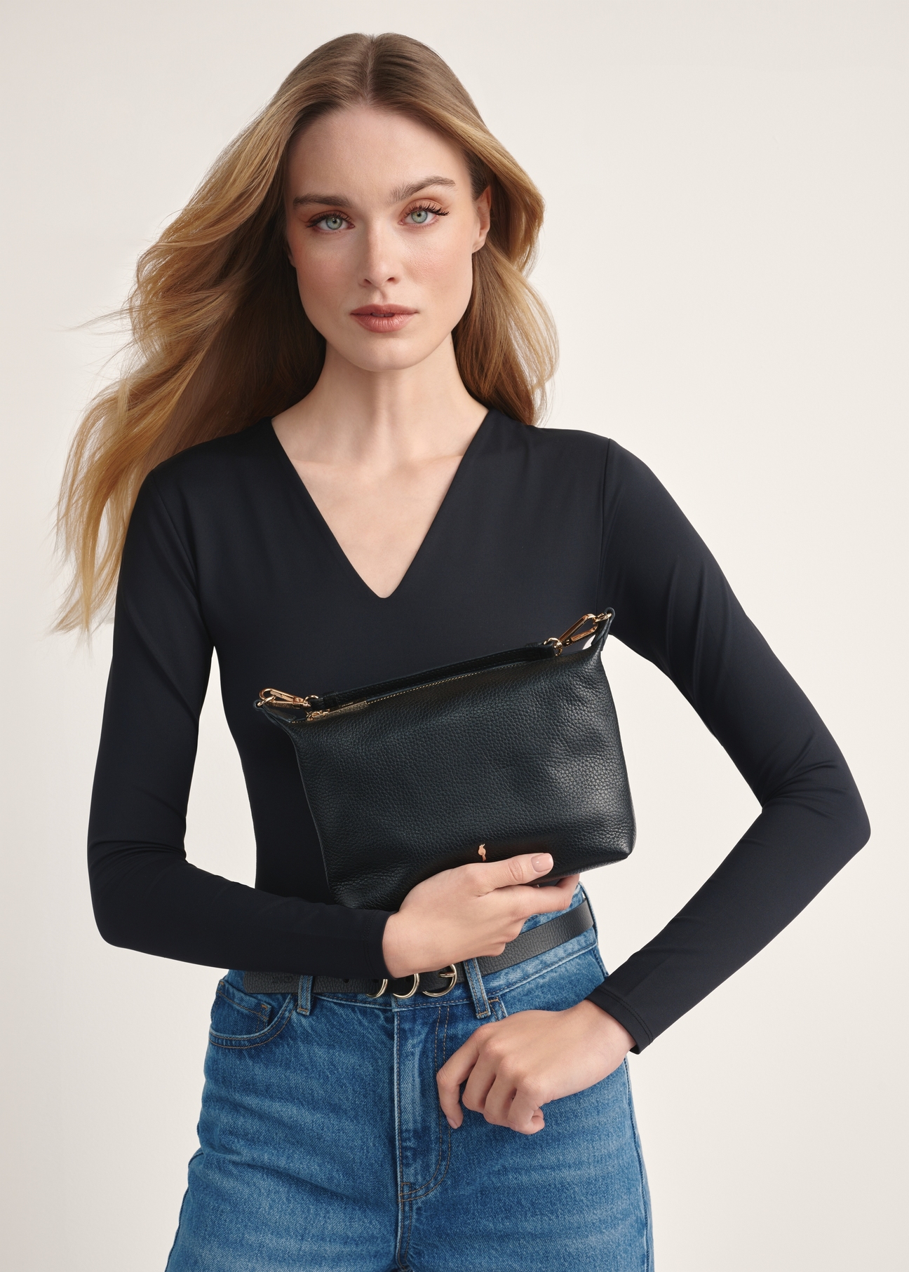 Black compact women's handbag TORES-0981D-99(Z25) - front view of the product on a model on a white background. Half of the silhouette visible.
