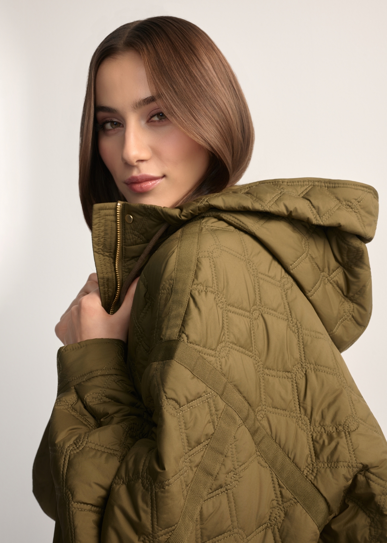 Olive green short oversize quilted jacket KURDT-0660-8D(W26) - back view of the product, on a model, against a light background. Close-up of the detail.