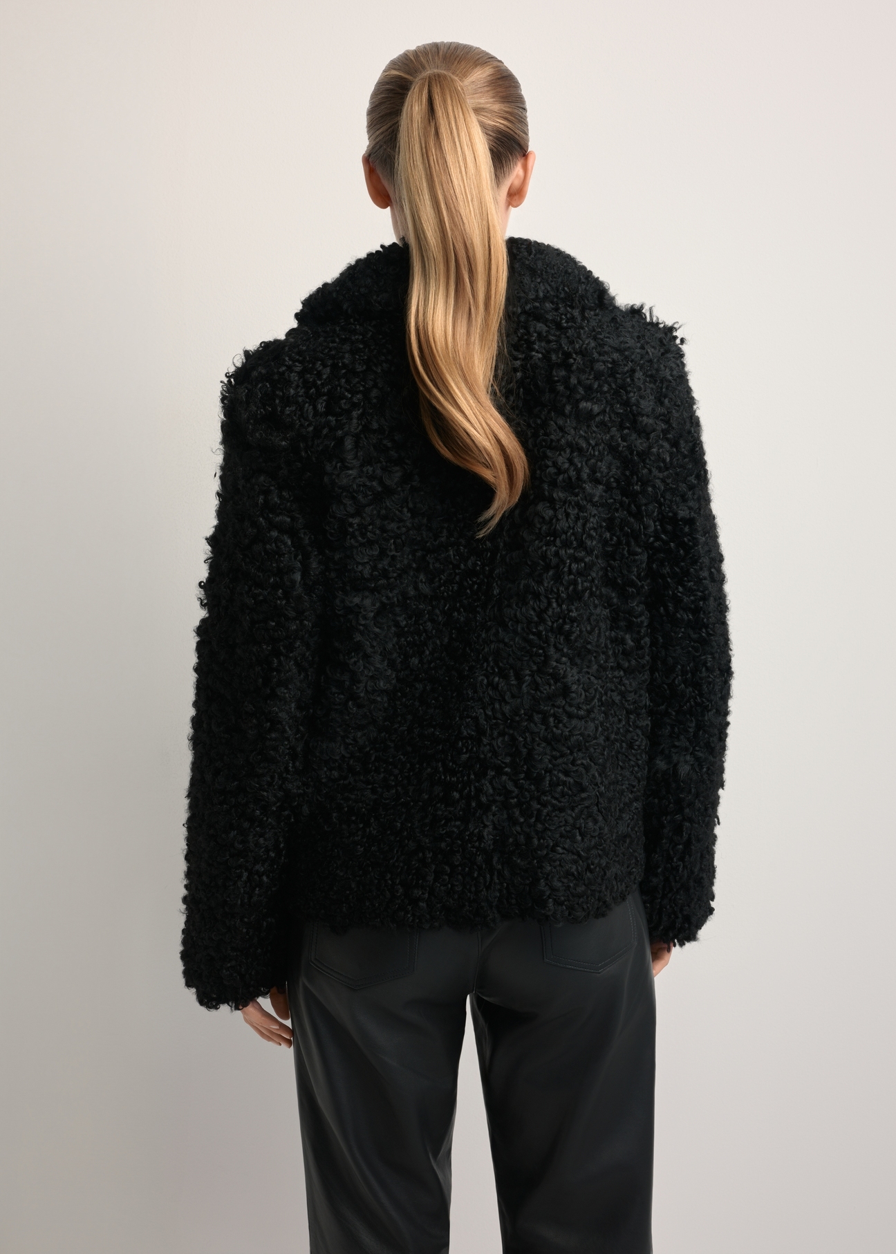 Women's black sheepskin coat KOZDS-0087-3095(Z25), back view of the product on the model. Half of the silhouette visible.