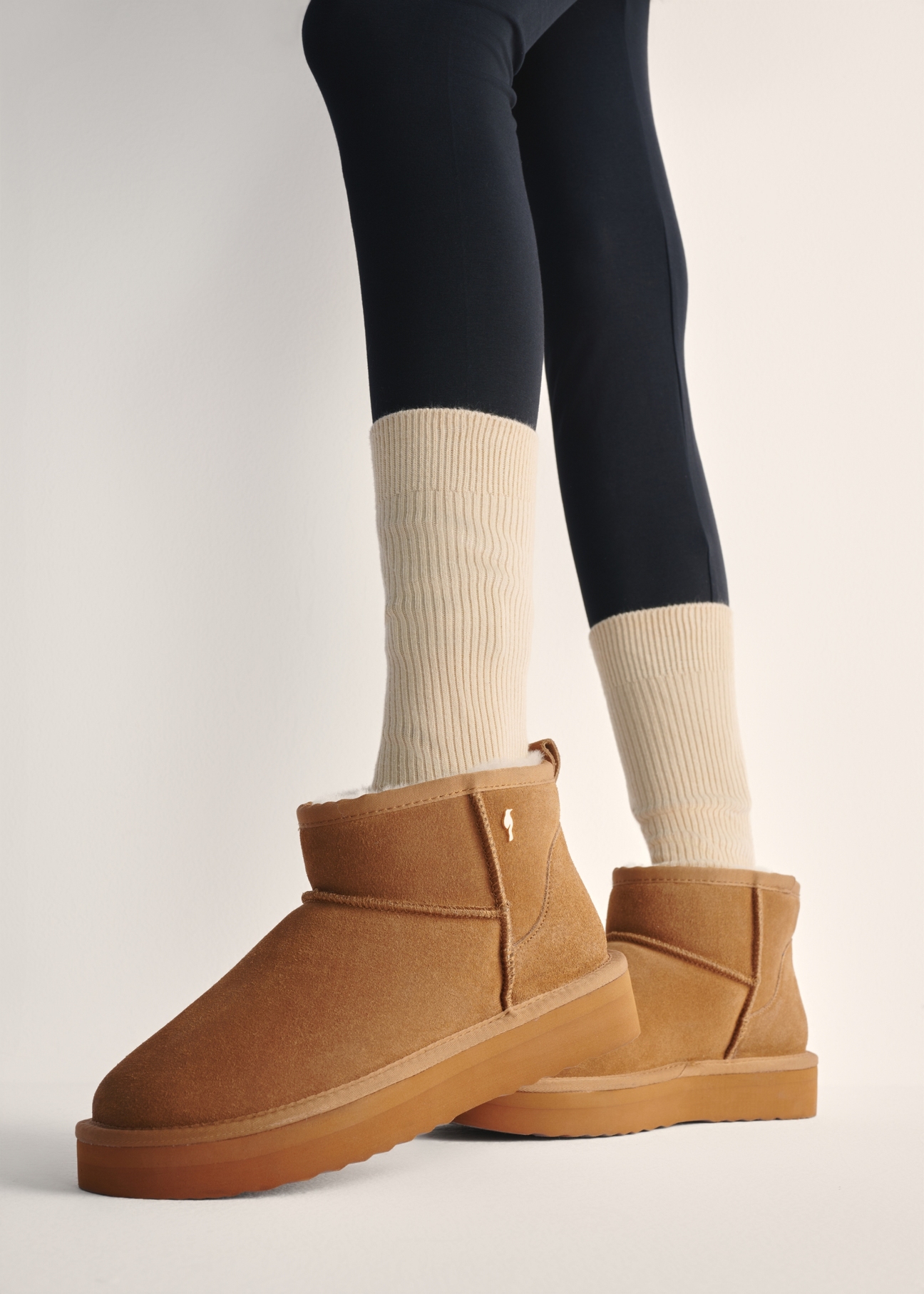 Beige short women's snow boots BUTYD-1138-82(Z25), view of the product on the model's feet against a light background.