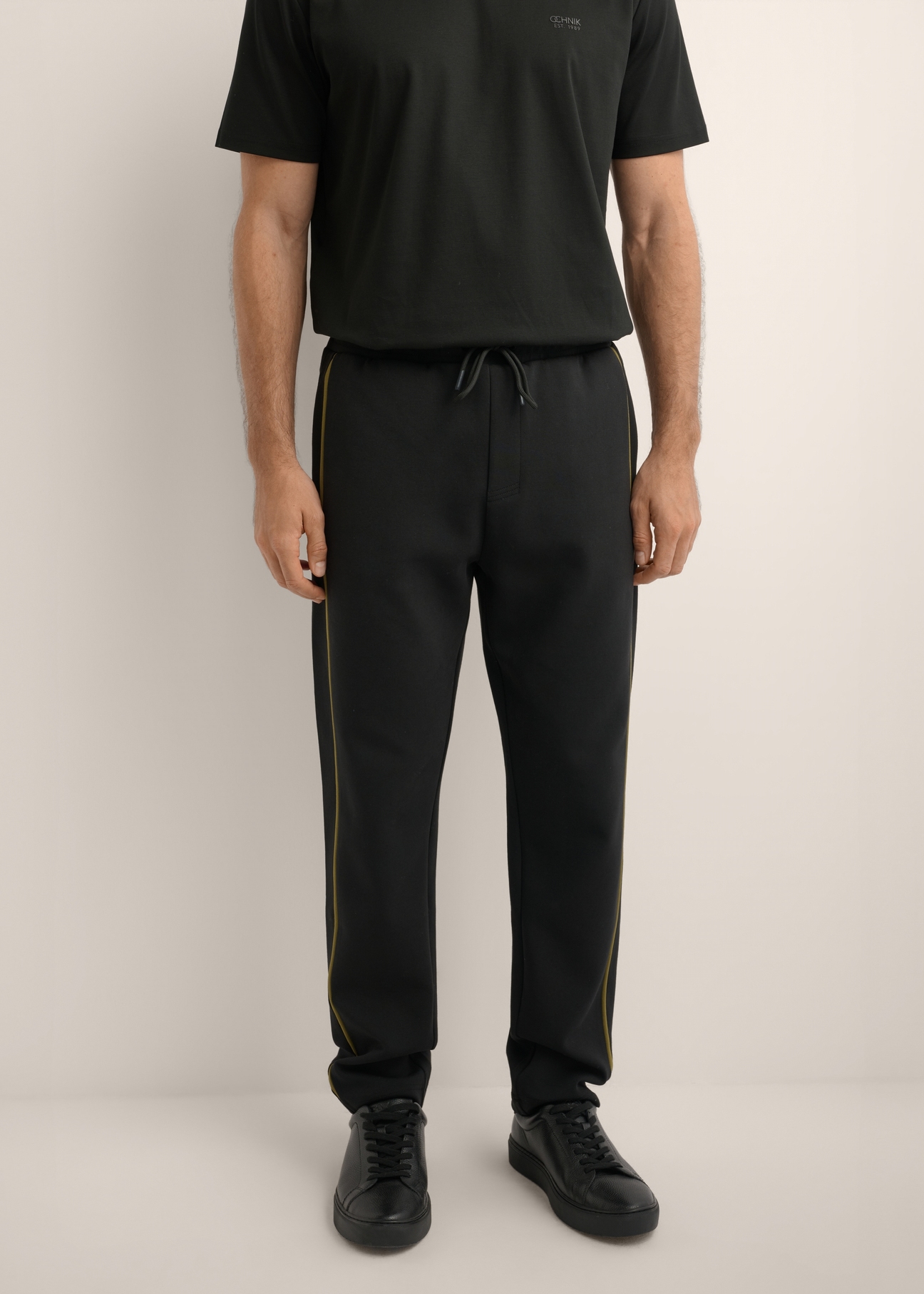 Men's black sweatpants SPOMT-0127-99(Z26), front view of the product on the model. Half of the silhouette visible.