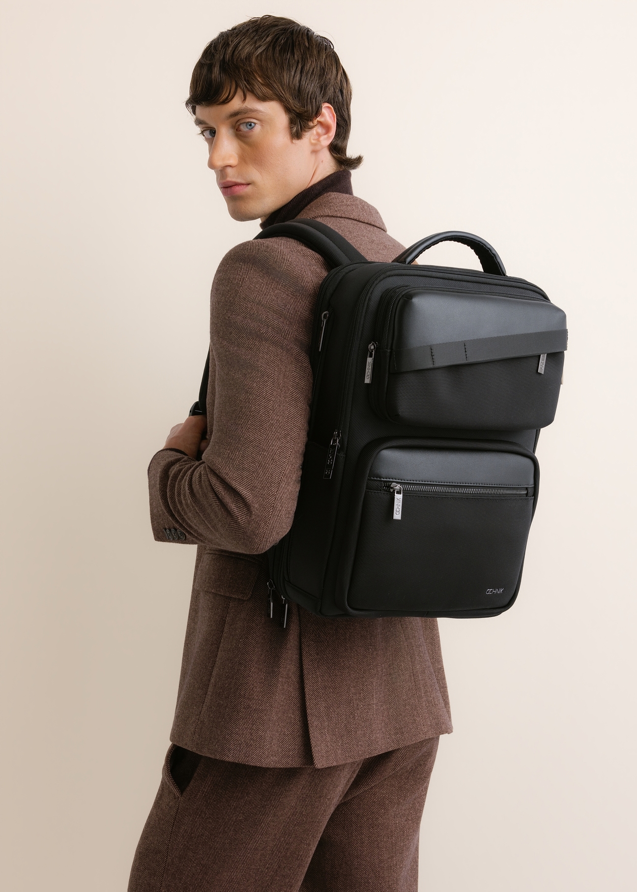 Black men's backpack with a pouch (TORMN-0442-99(Z26)), front view on a model against a light background.