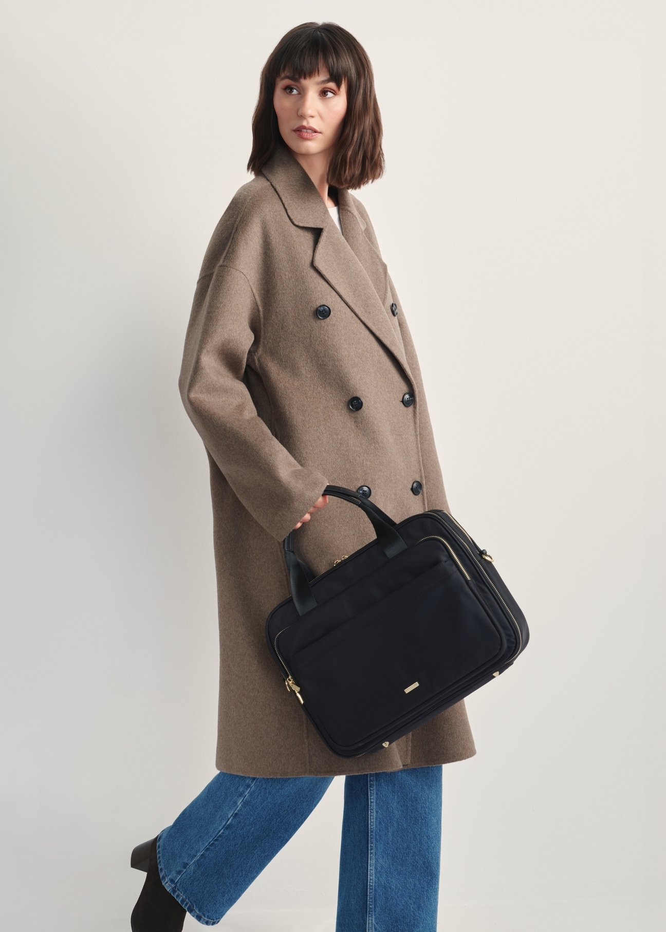 Black roomy women's laptop bag TOREN-0320-99(Z25) - front view of the product on a model against a white background. The entire silhouette is visible from the side.