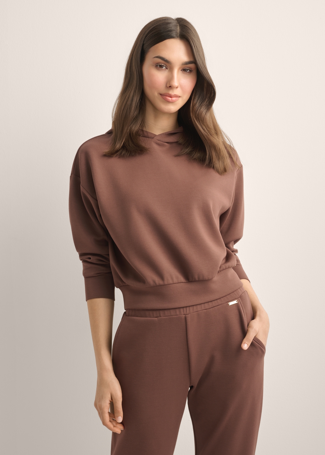 Women's brown hooded sweatshirt BLZDT-0118-1H(Z26), front view of the product on the model. Half of the silhouette visible.