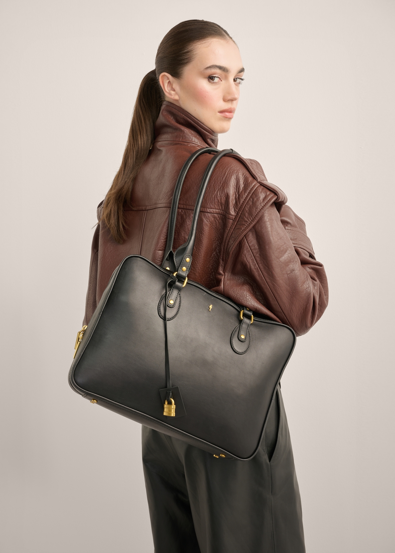 Black leather women's bag TORES-1370-99(Z26), front view of the product on a model. Half of the silhouette visible.
