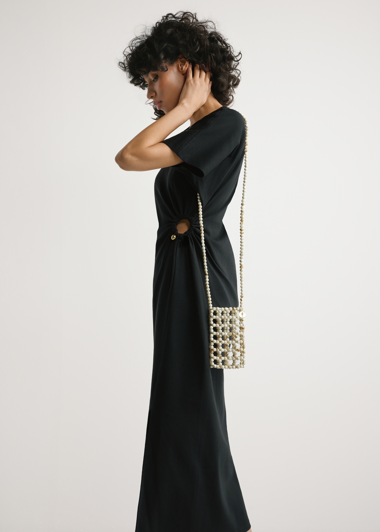 TOREC-1145-0C(W26) Beaded Phone Case - slightly diagonal view of the product, on a model against a light background. Knee-length silhouette visible.