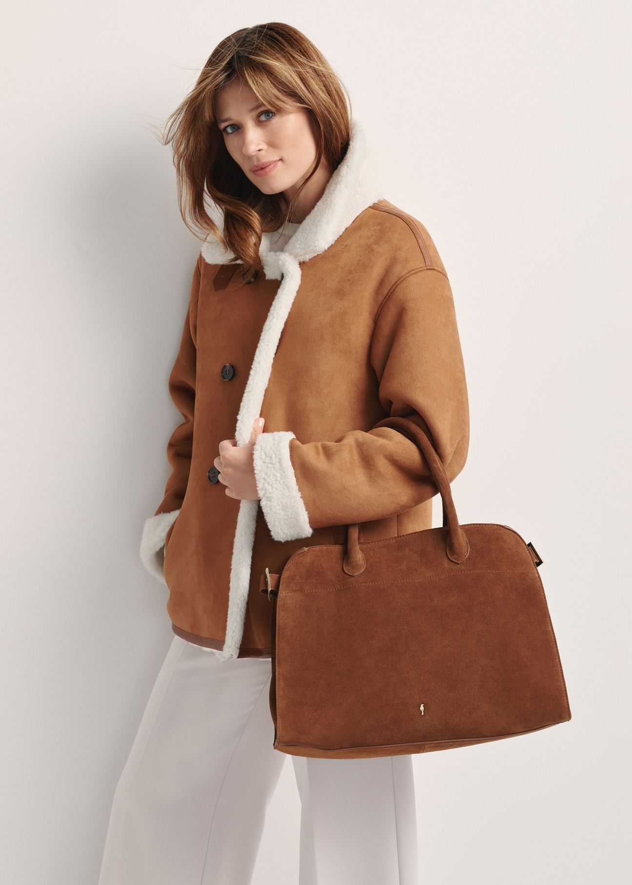 Cognac-colored suede handbag TORES-1191-88(Z25), front view of the product on a model, half of the silhouette visible.