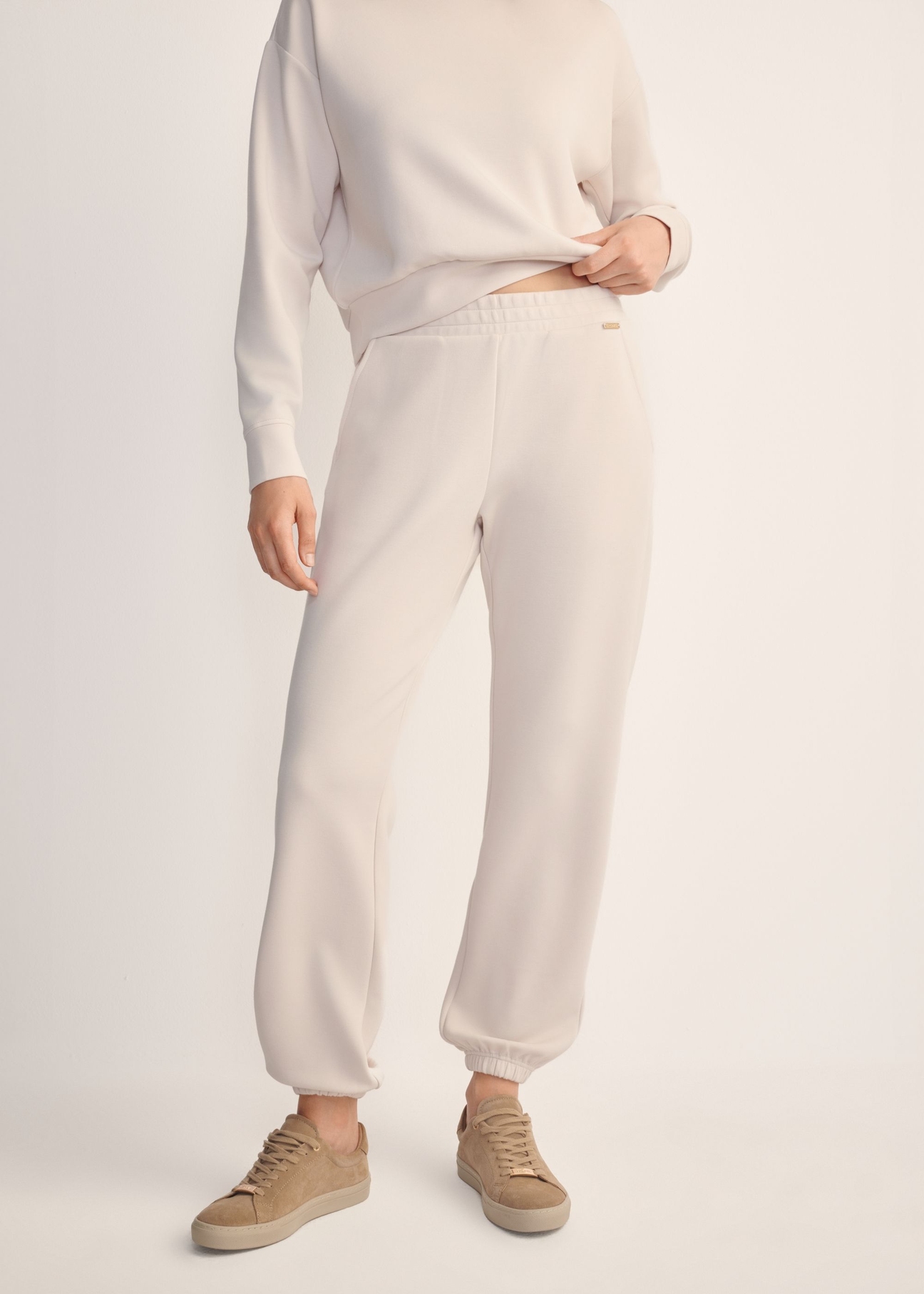 Light beige women's trousers SPODT-0117-80(Z25), front view of the product on the model. Half of the silhouette visible.