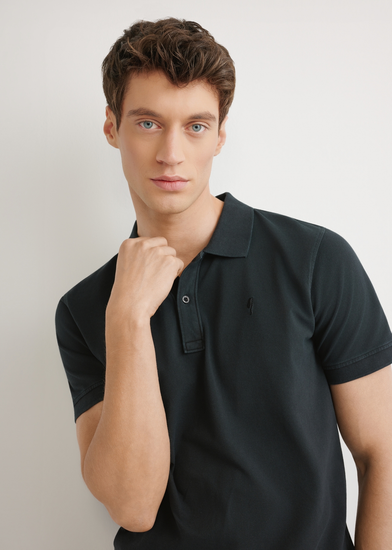 Men's black polo shirt POLMT-0055A-99(W26), close-up of the product from the front on the model's silhouette.