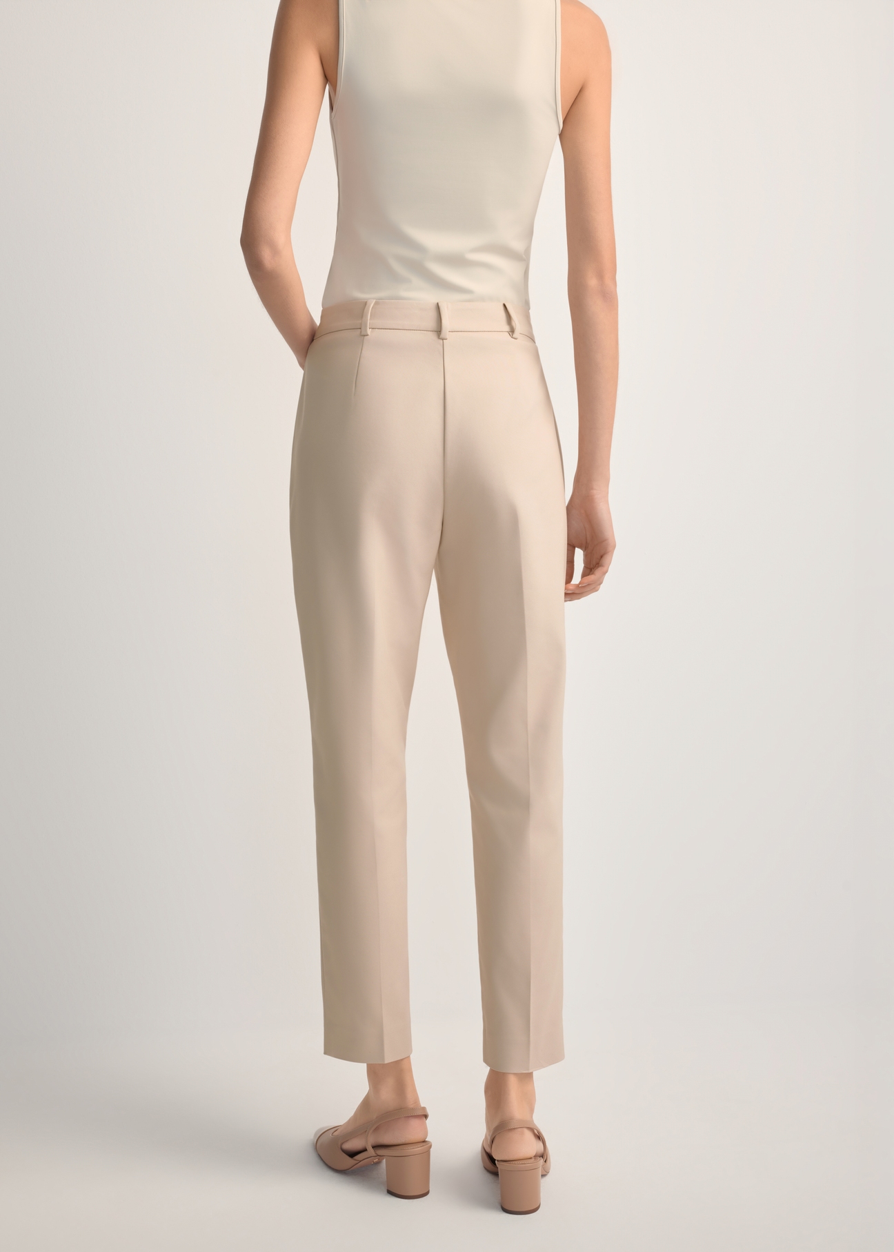 Beige women's pleated trousers SPODT-0090-1B(W26), back view of the product on the model. Half of the silhouette visible.