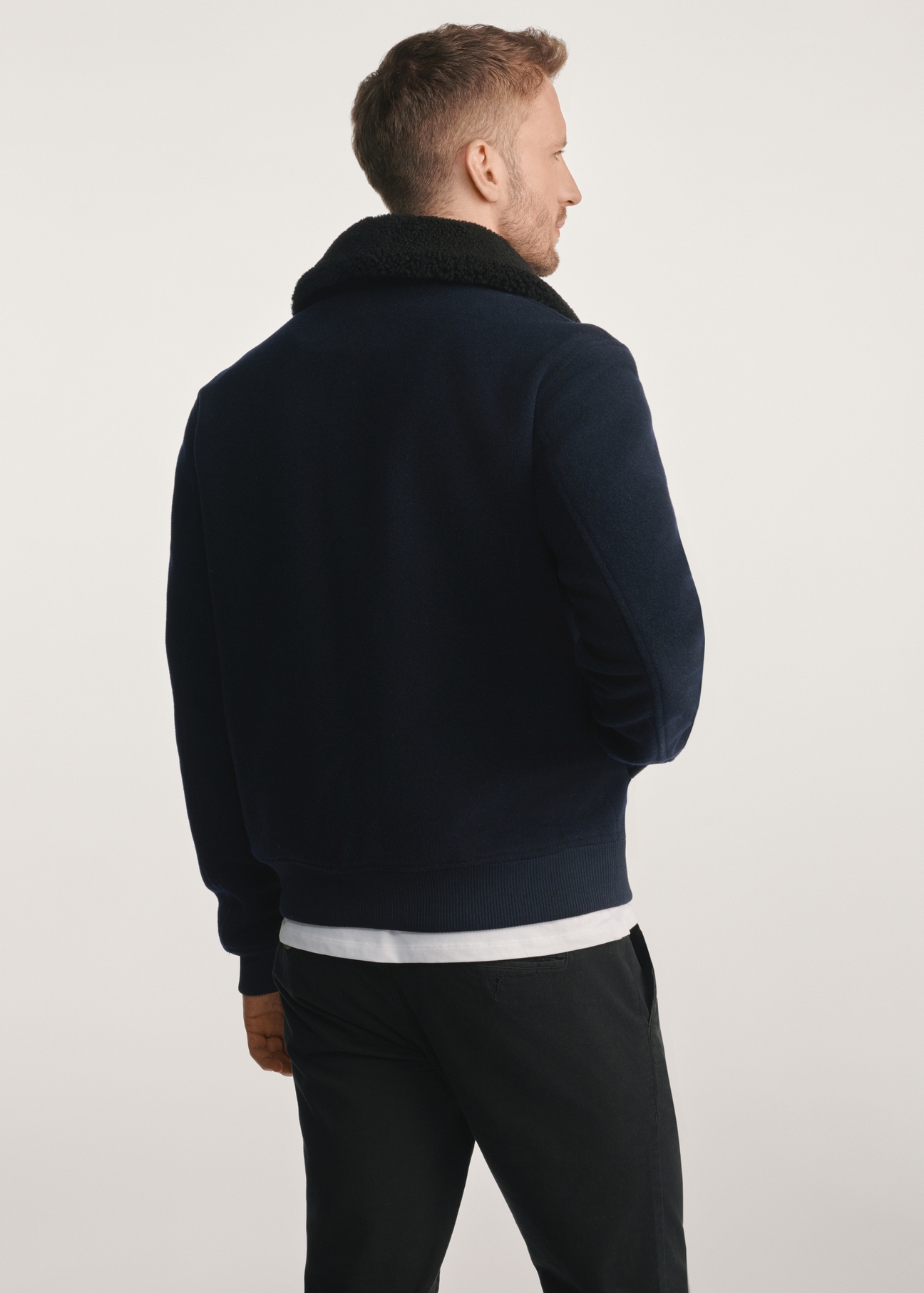 Navy blue men's sheepskin jacket PLAMT-0009-69(Z25), product visible from the back on the model, half of the silhouette visible.