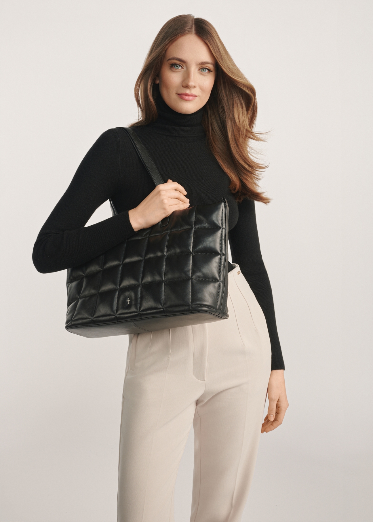 Large black quilted leather handbag TORES-1196-99(Z25) - product view slightly diagonal on a model against a white background. Half of the silhouette visible.