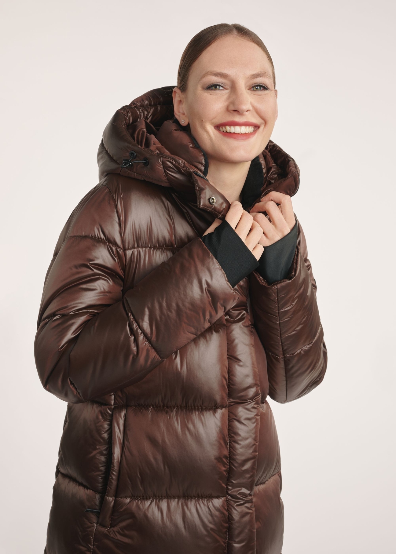 Brown long women's winter jacket KURDT-0531-1H(Z26) - front view on a model on a white background. Half of the silhouette visible.