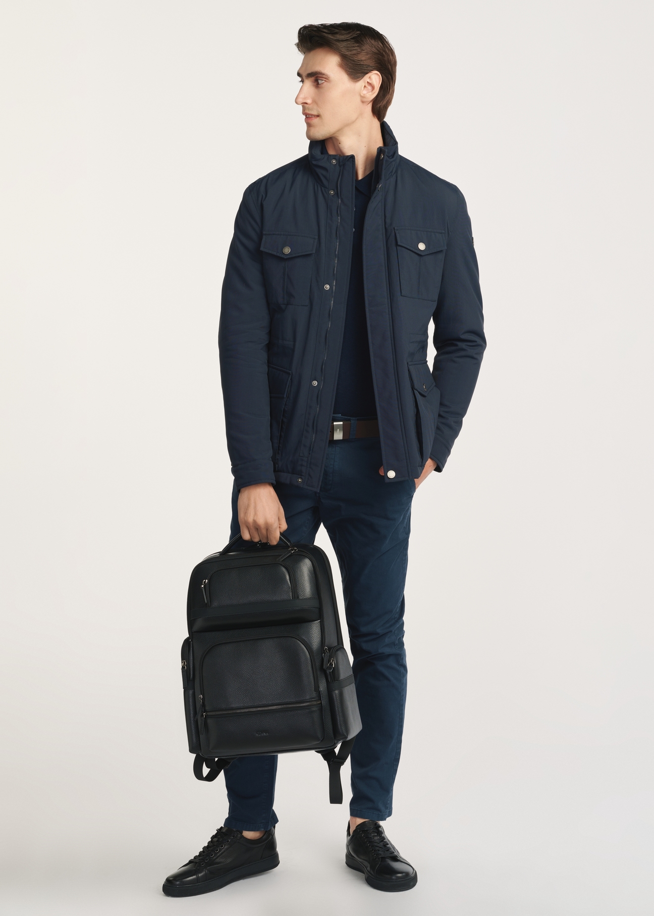 Black spacious men's backpack PLCMS-0022-99(Z25), front view of the product on the model, half of the silhouette visible.
