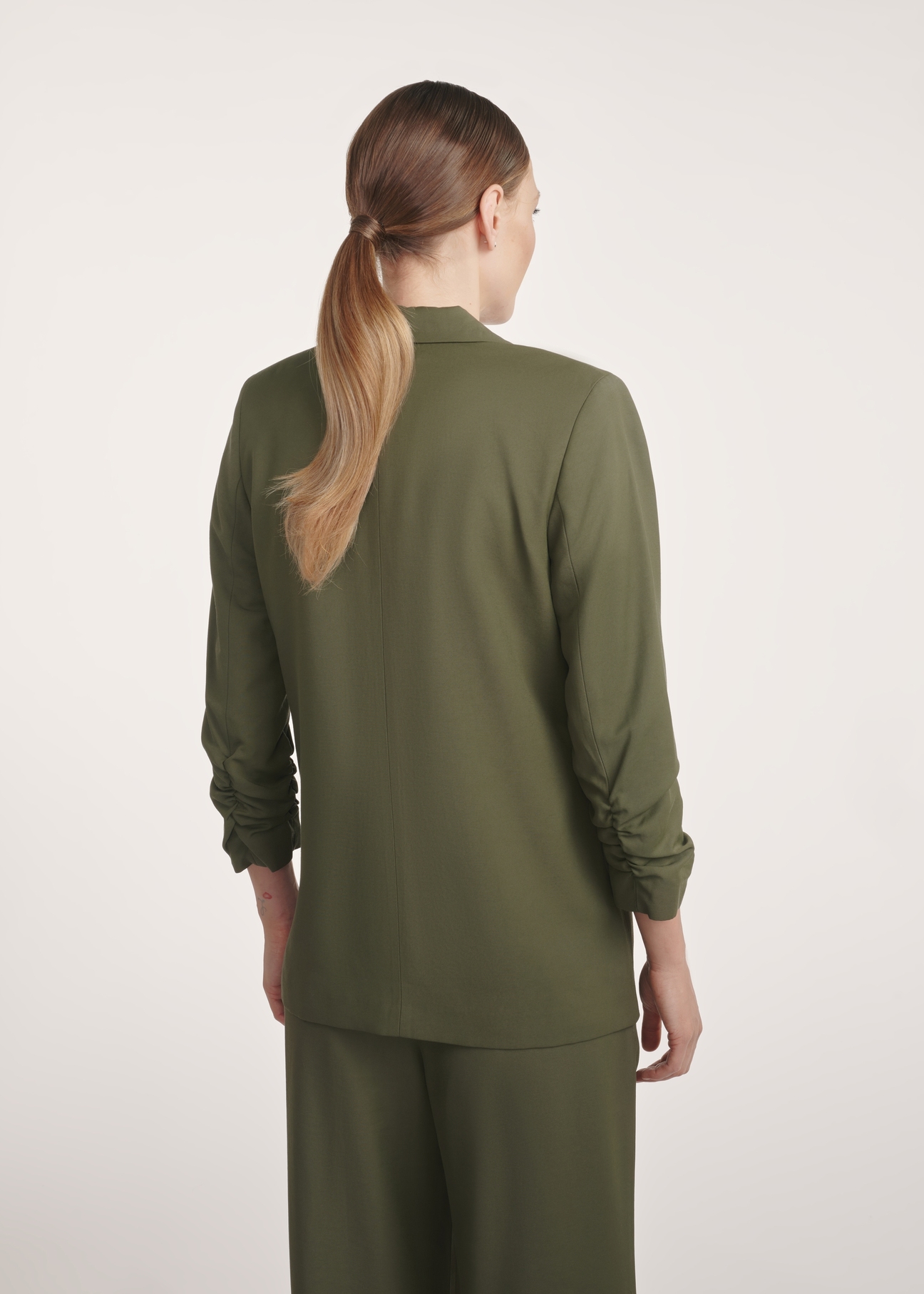 Women's khaki blazer ZAKDT-0043-55(Z25), product view from the back on the model. Half of the silhouette visible.