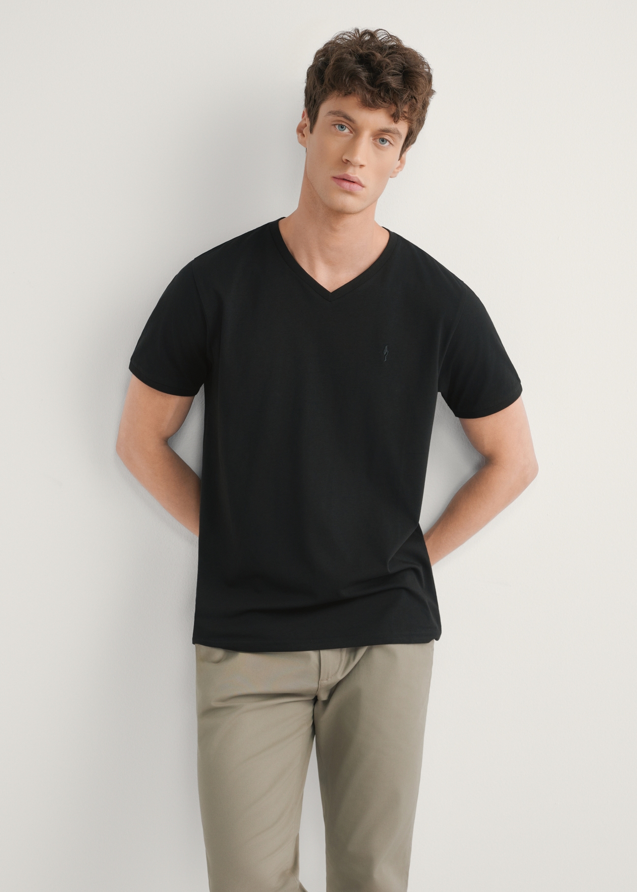 Black basic men's T-shirt with logo TSHMT-0088-99(W25), front view of the product on the model, half of the silhouette visible.