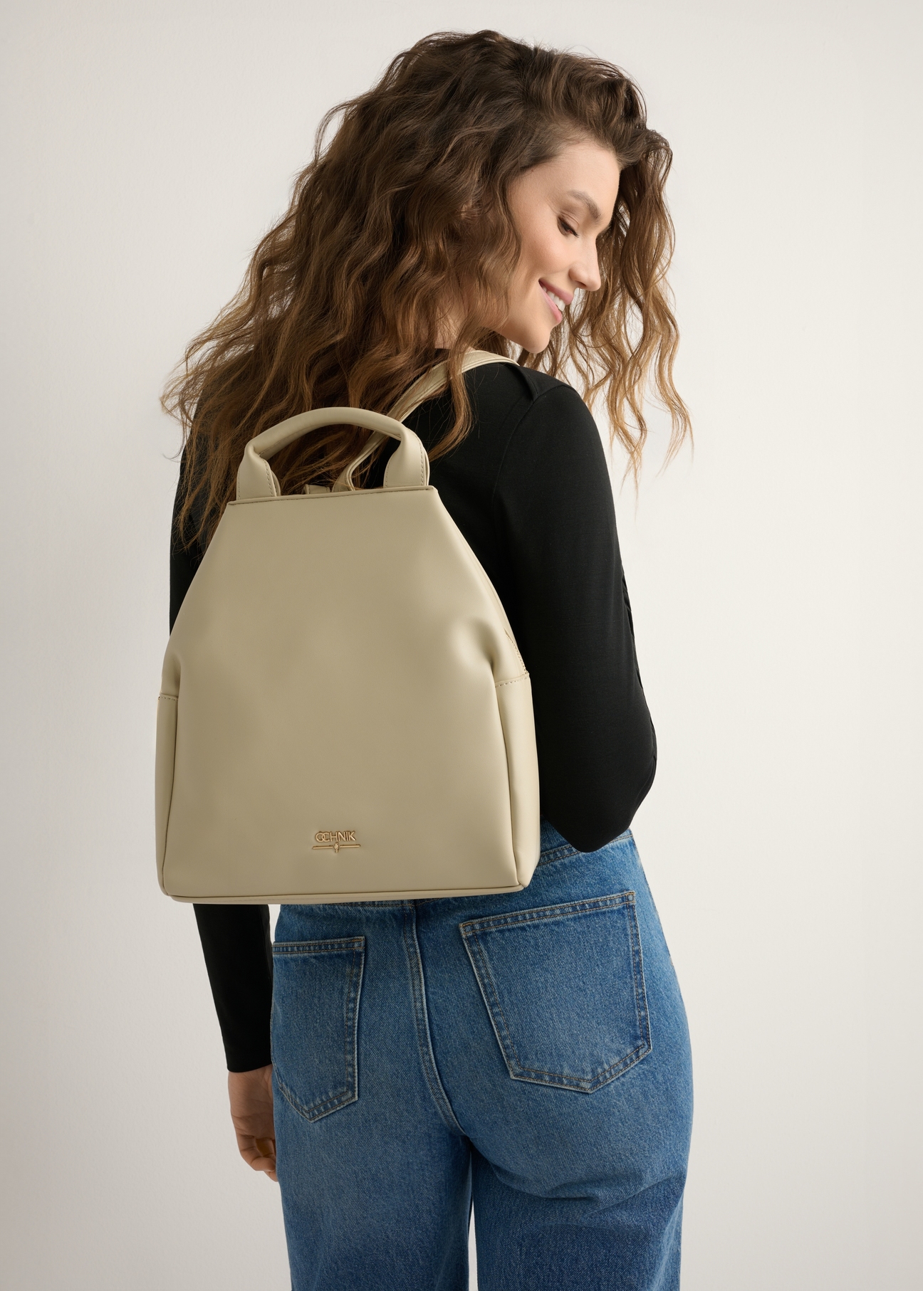 Cream women's imitation leather backpack TOREC-0923-0B(W26), product view on model's back. Half of silhouette visible.