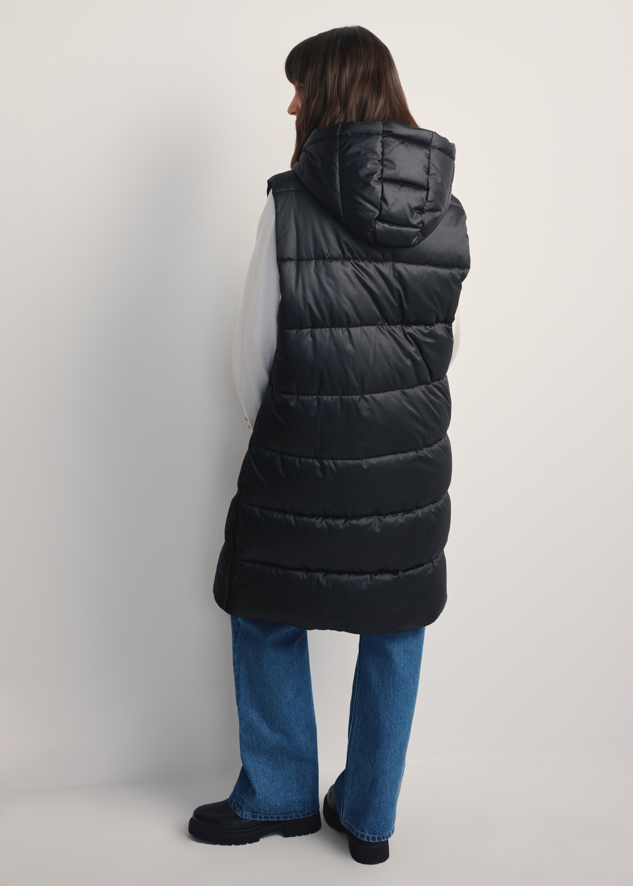 Black insulated women's vest KAMDT-0028-99(Z25), product view from the back on the model, the entire silhouette is visible.