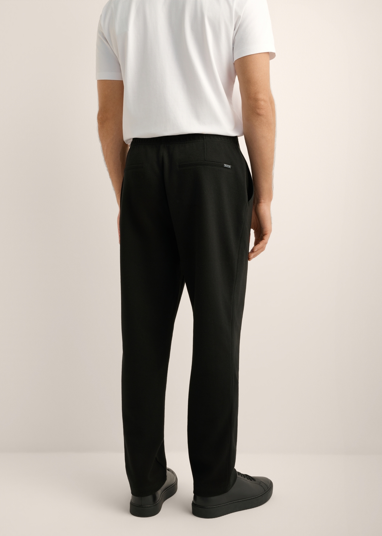 Men's straight-leg knit pants, model SPOMT-0126-99(Z26). Rear view of the product on a model. Half of the figure is visible.