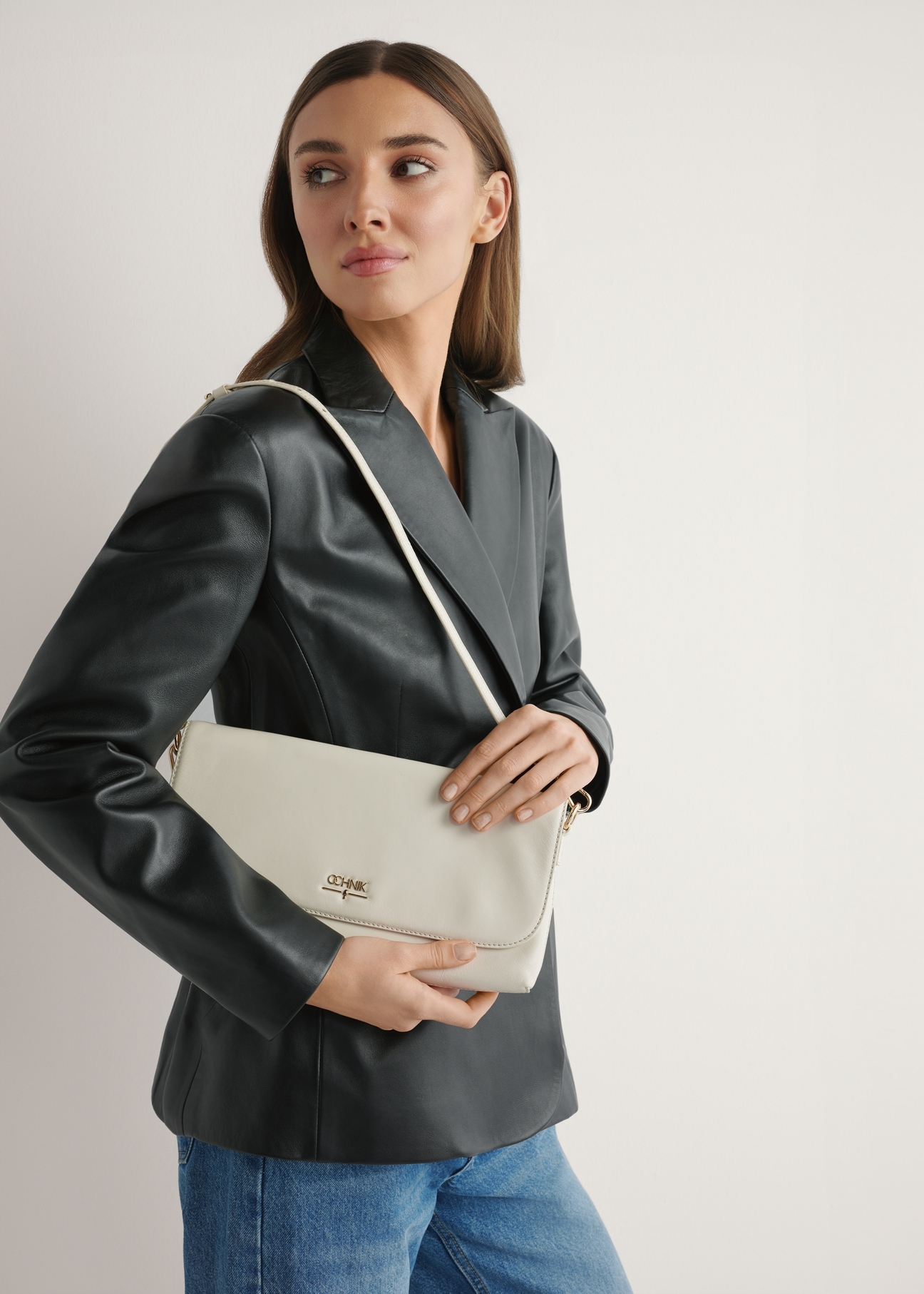 Cream leather clutch bag TORES-1271-0B(W26) - front view of the product, on a model, against a light background. Half-length silhouette visible.
