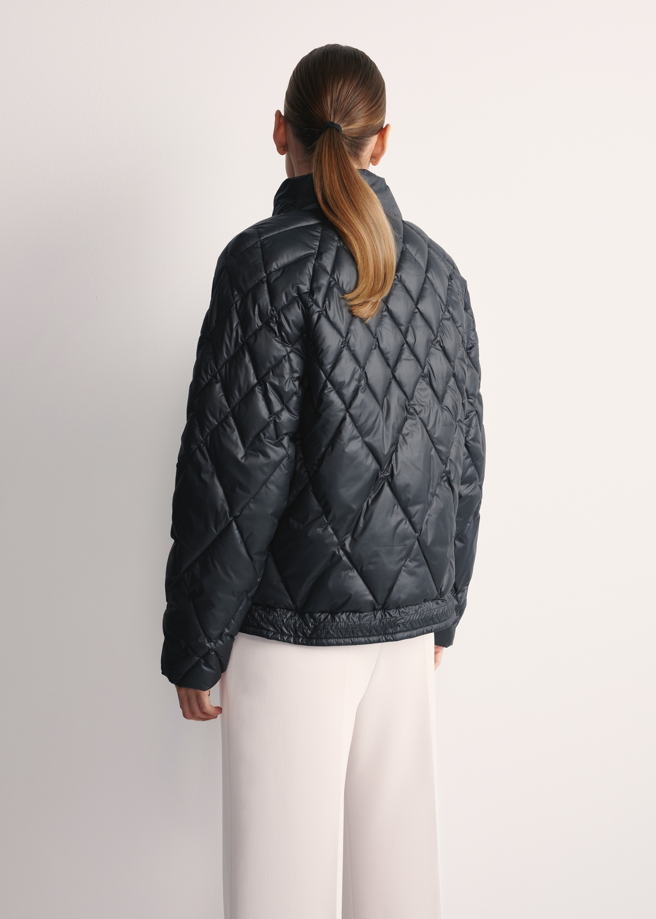 Black women's quilted jacket KURDT-0597-98(Z25), product view from the back on the model, half of the silhouette visible.
