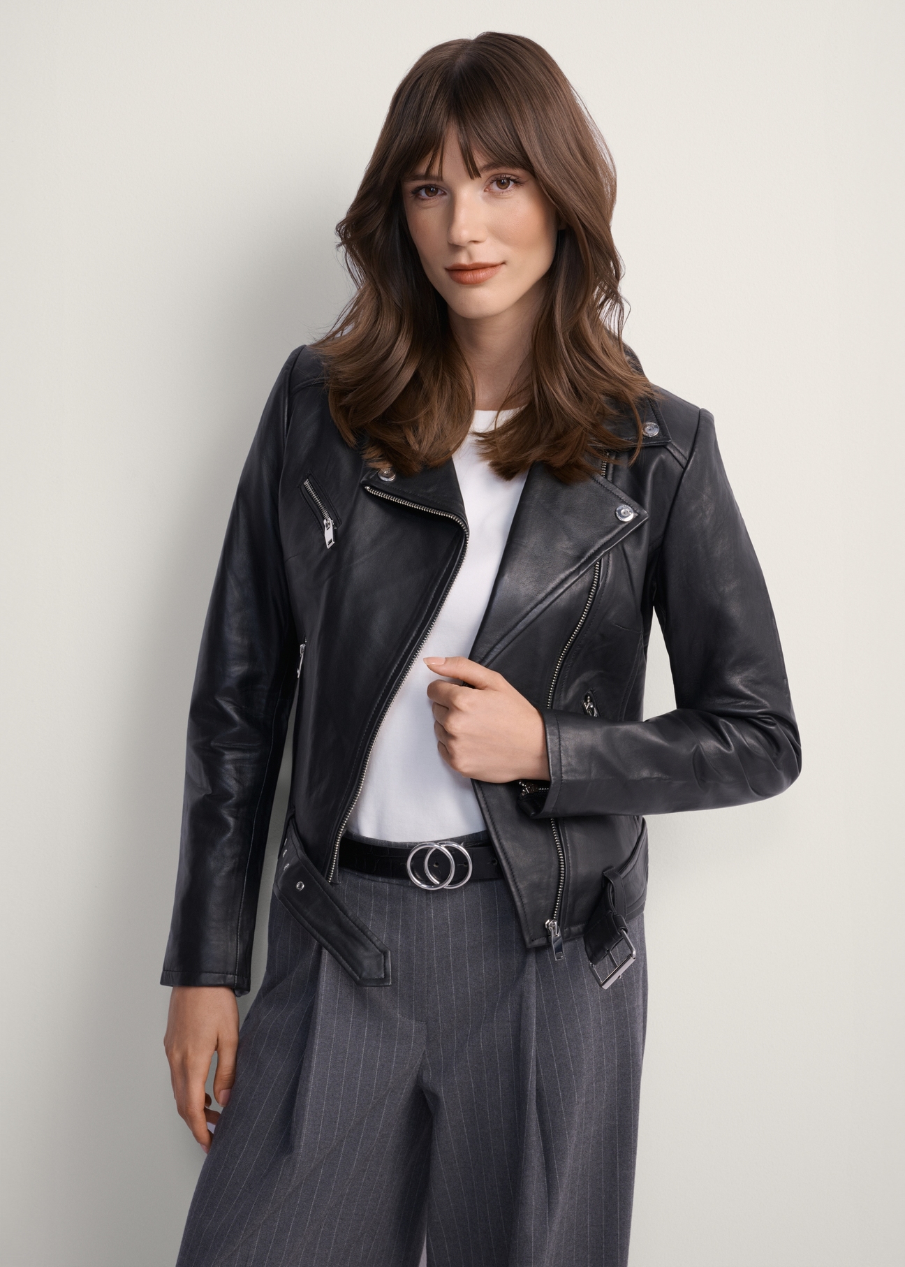 Women's leather biker jacket KURDS-0274-5491(KS), front view of the product on the model. Half of the silhouette visible.