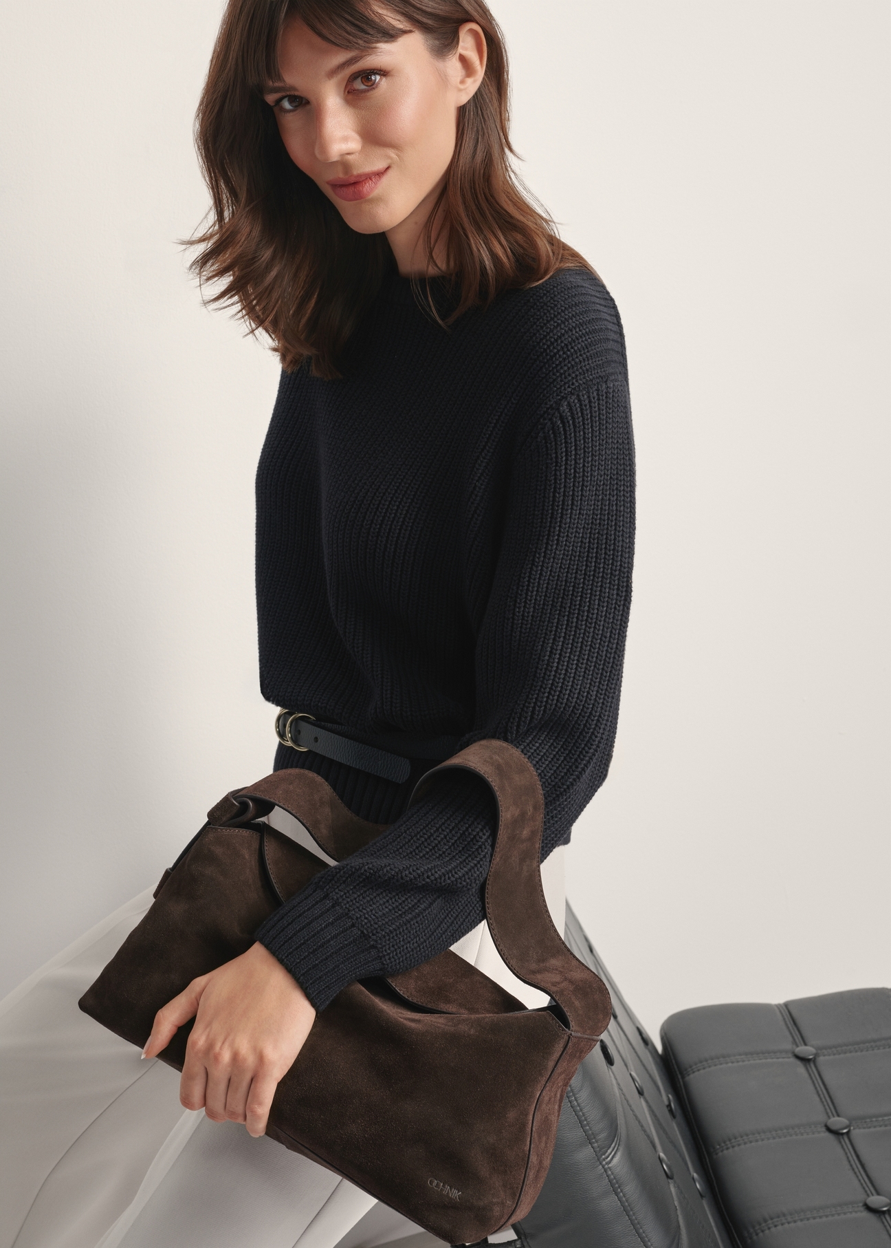 Dark brown suede handbag TORES-1186-89(Z25), front view of the product on a model, half of the silhouette visible.