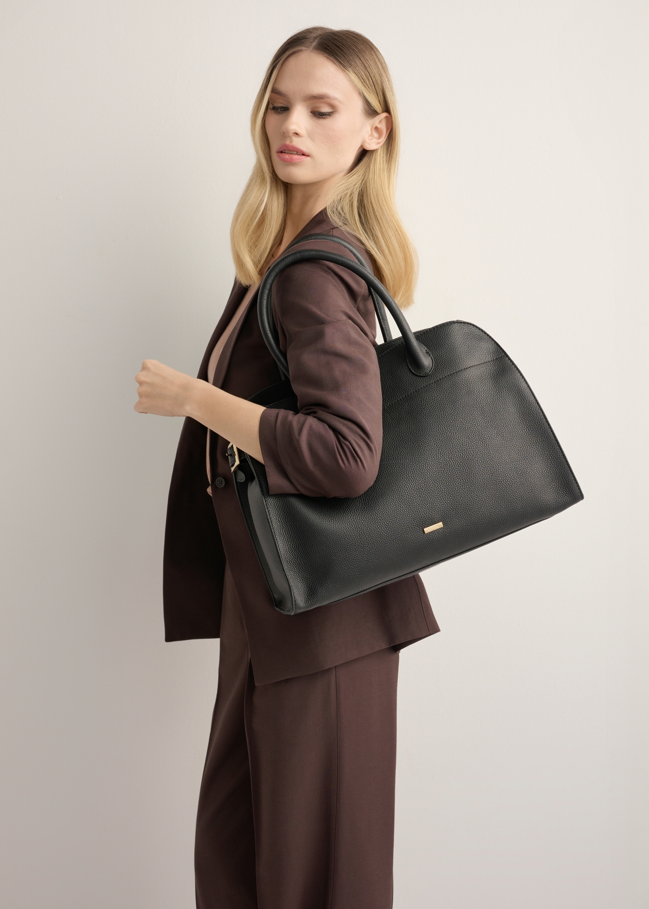 Black leather handbag TORES-1191-9I(Z26), product view on model's shoulder. Half of silhouette visible.