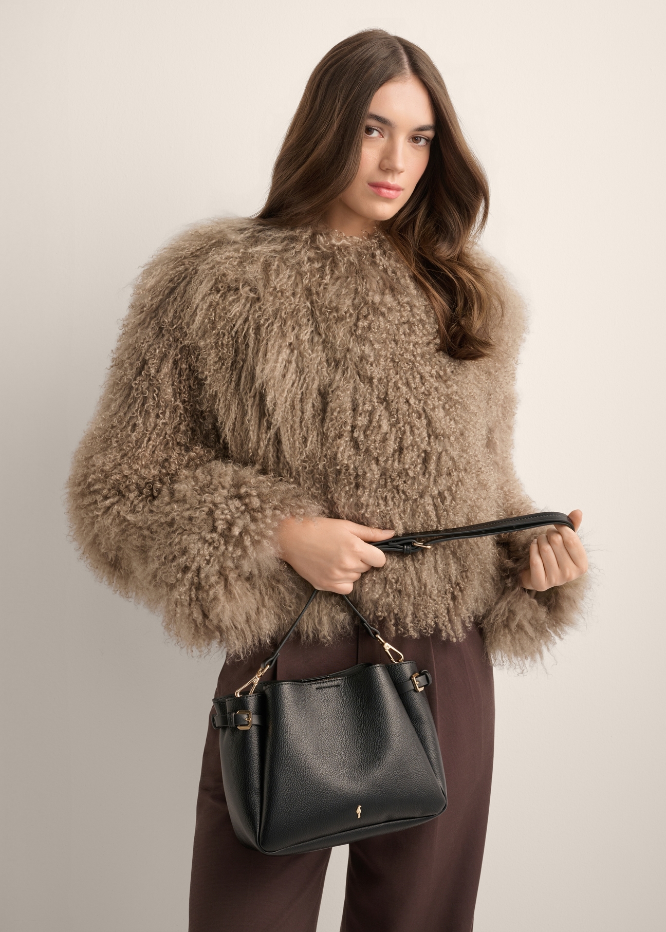 Black women's shoulder bag TOREC-1345-9I(Z26), diagonal view of the product on the model. Half of the silhouette visible.