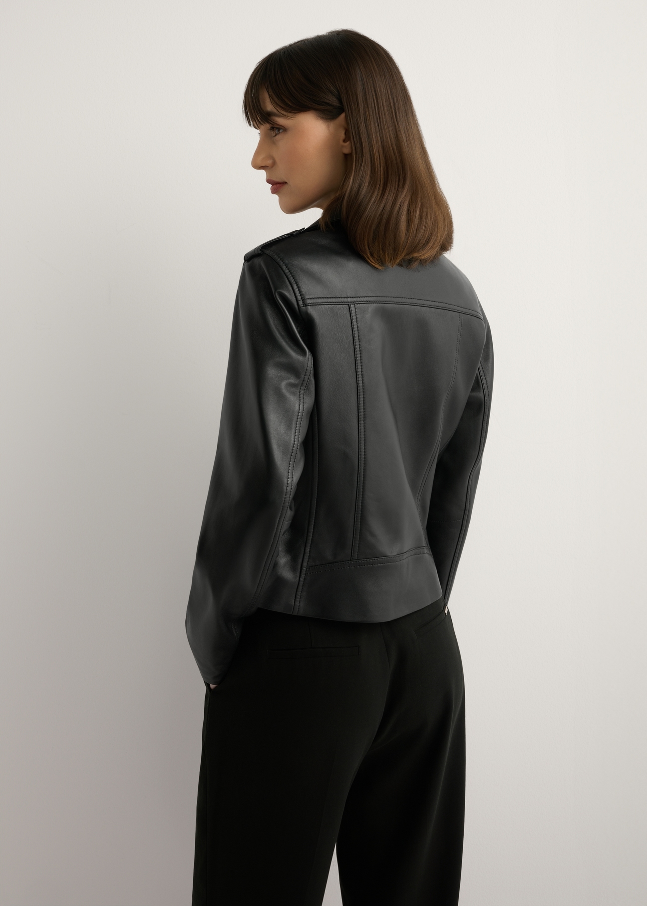 Women's black leather jacket KURDS-0601-99(W26), back view of the product on the model. Half of the silhouette visible.