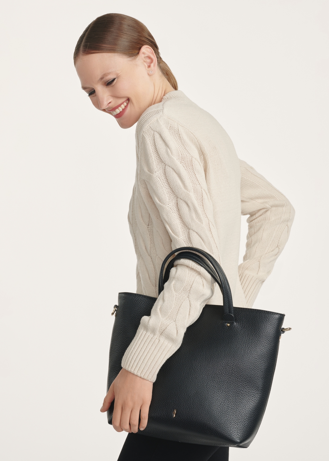Black leather shopper bag TORES-0728D-99(Z25), front view of the product on the model, half of the silhouette visible.