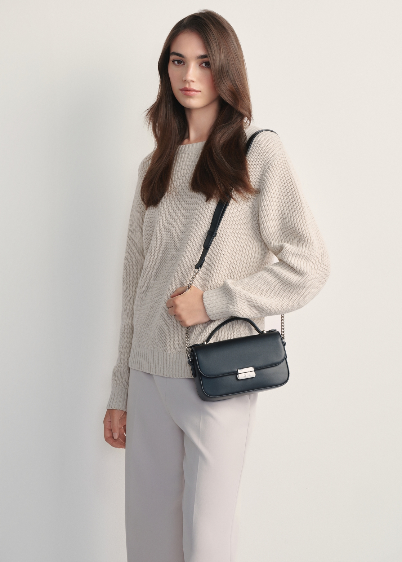 Women's black messenger bag TOREC-1066-99(Z25) - front view of the product on a model, against a white background. Knee-length silhouette visible from the side.