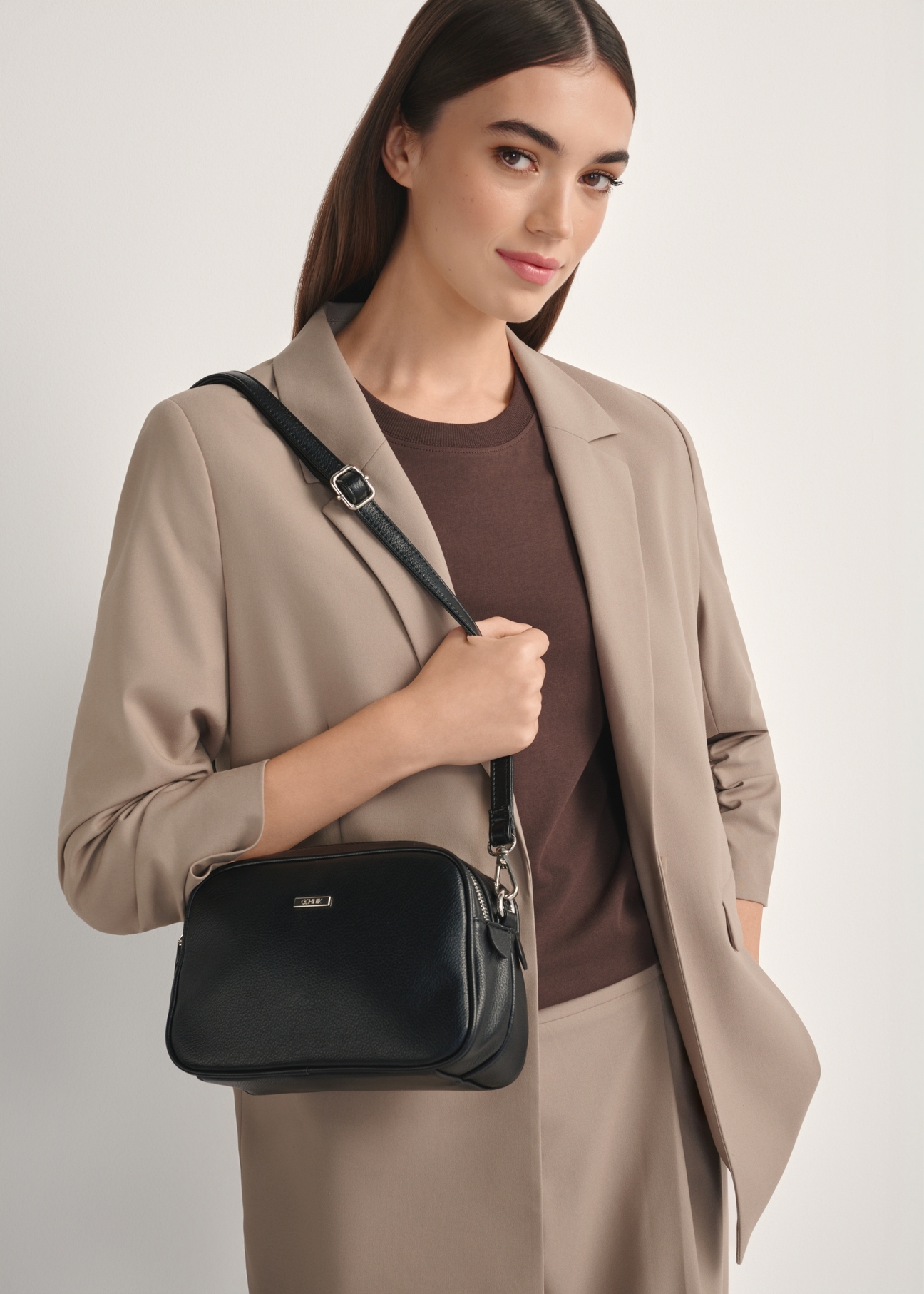 Black medium women's handbag TOREC-1121-9I(W26), front view of the product on a model, half of the silhouette visible.