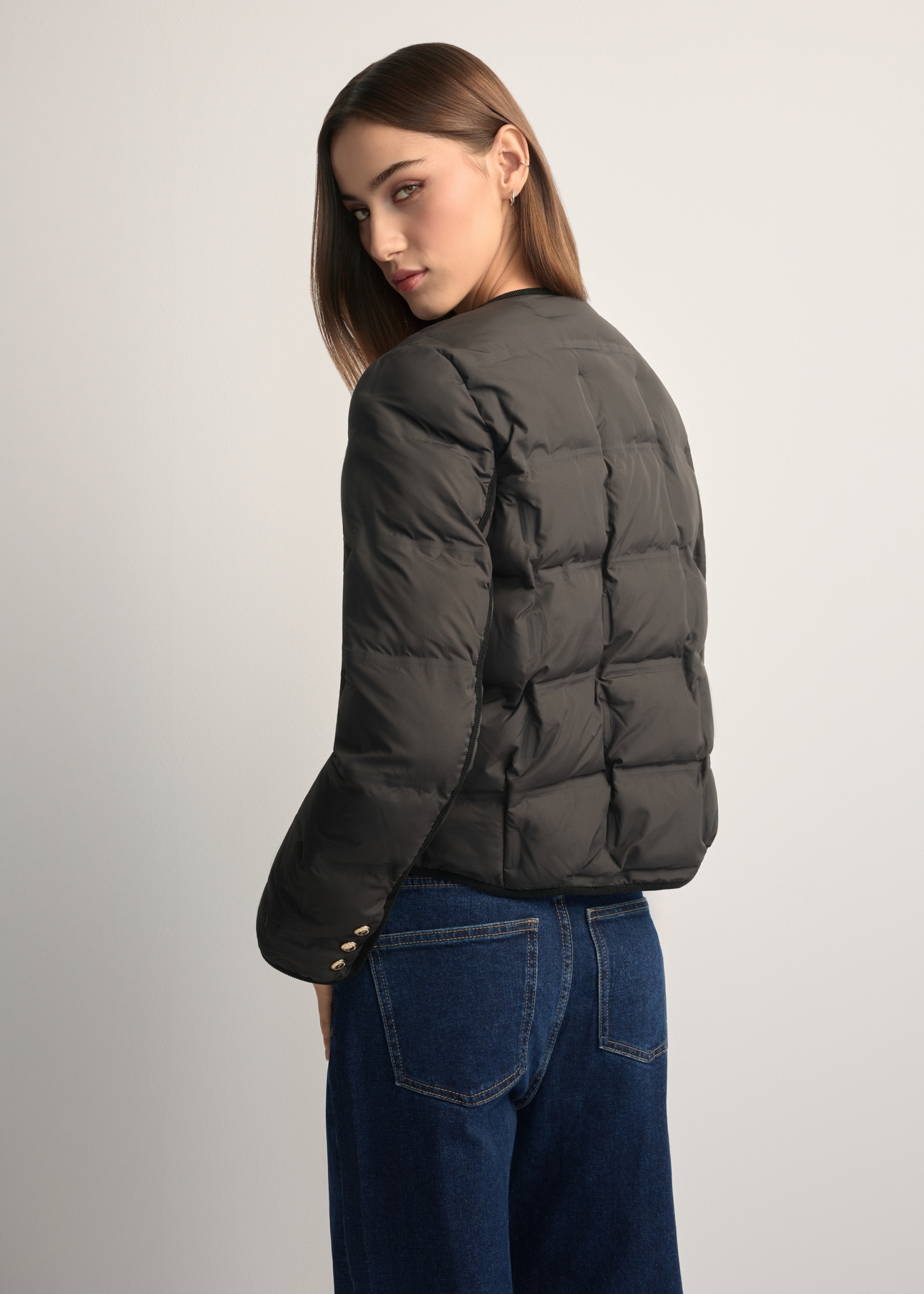 Black women's short jacket KURDT-0621-99(W26), back view of the product on the model. Half of the silhouette visible.