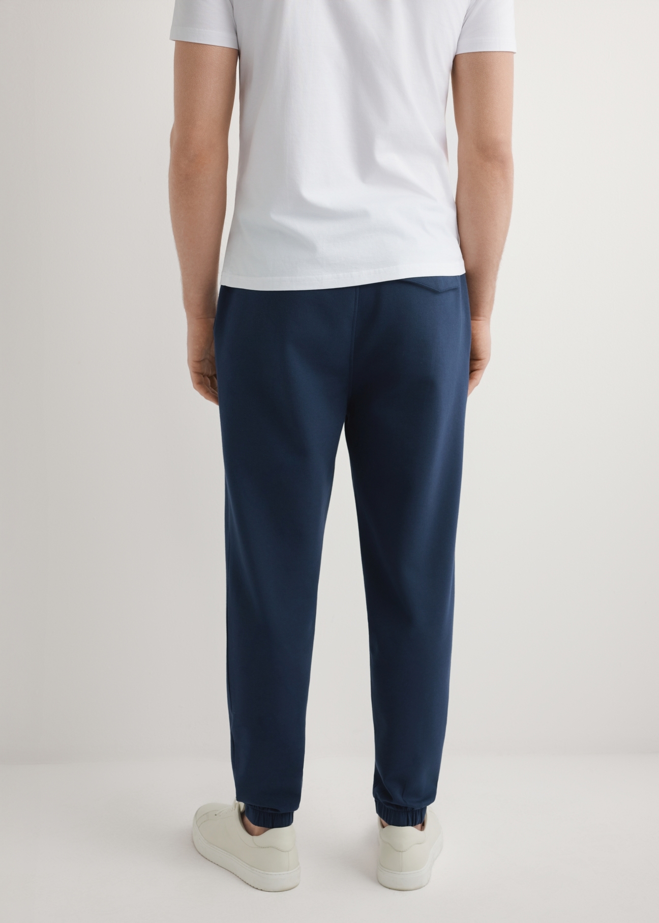 Men's navy blue sweatpants SPOMT-0109-7E(W26), product view from the back on the model. Half of the silhouette visible.