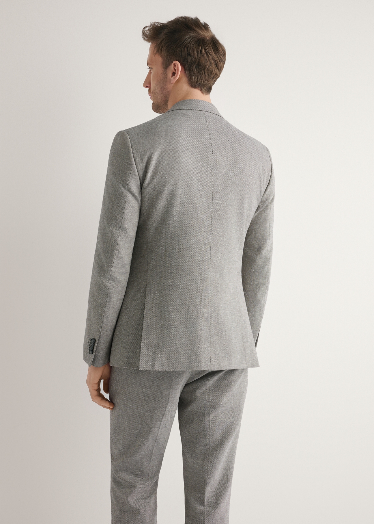 Men's beige suit jacket MARMT-0013-1B(W26), back view of the product on the model. Half of the silhouette visible.
