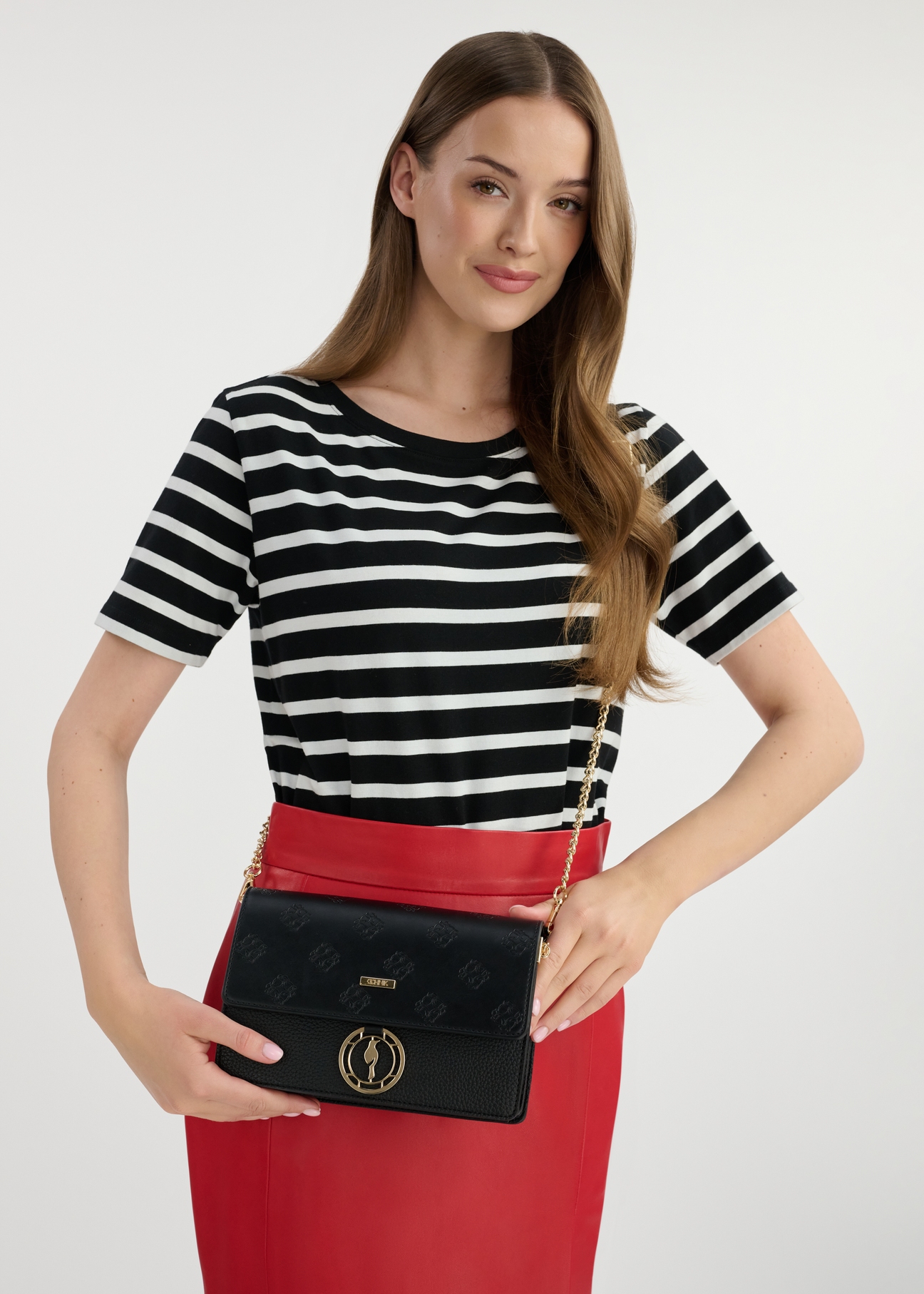 Black women's monogram handbag TOREC-0536B-99(W25), front view of the product on the model. Half of the silhouette visible.