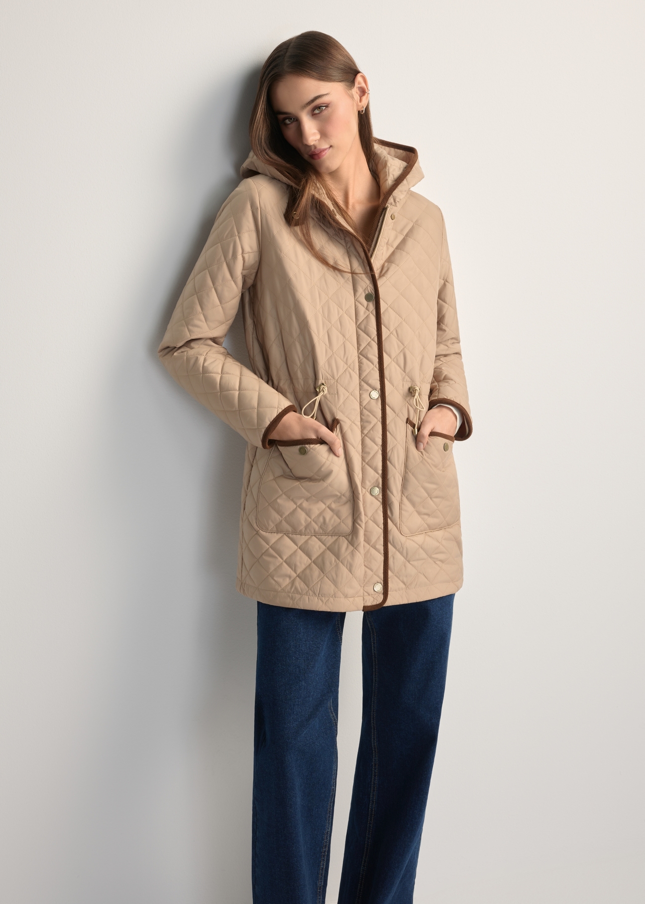 Beige women's quilted jacket KURDT-0646-1B(W26), front view of the product on the model. Half of the silhouette visible.