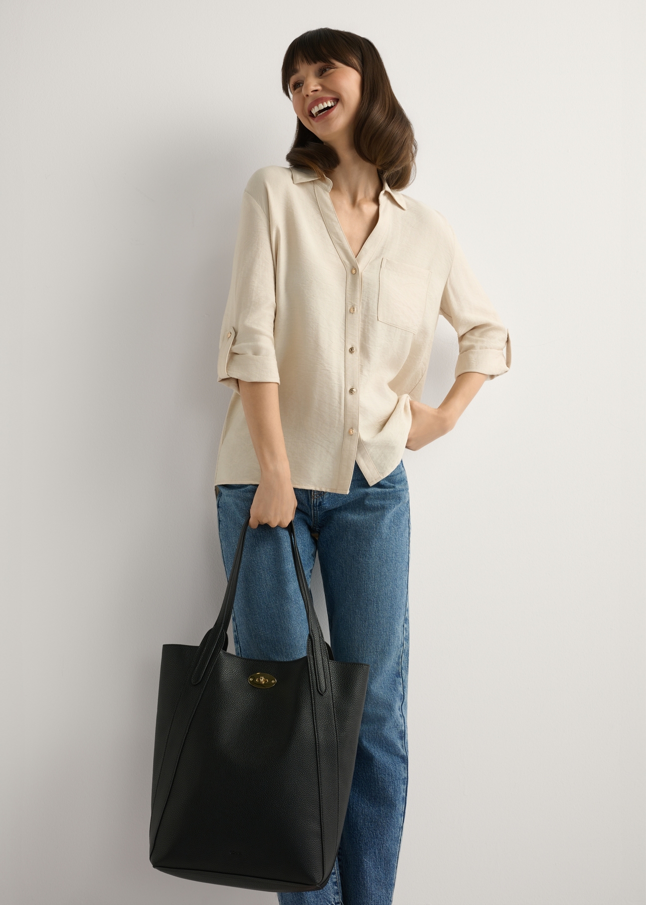 Large black women's shopper handbag TOREC-1142-9I(W26), view of the product in the model's hand. Full body visible.