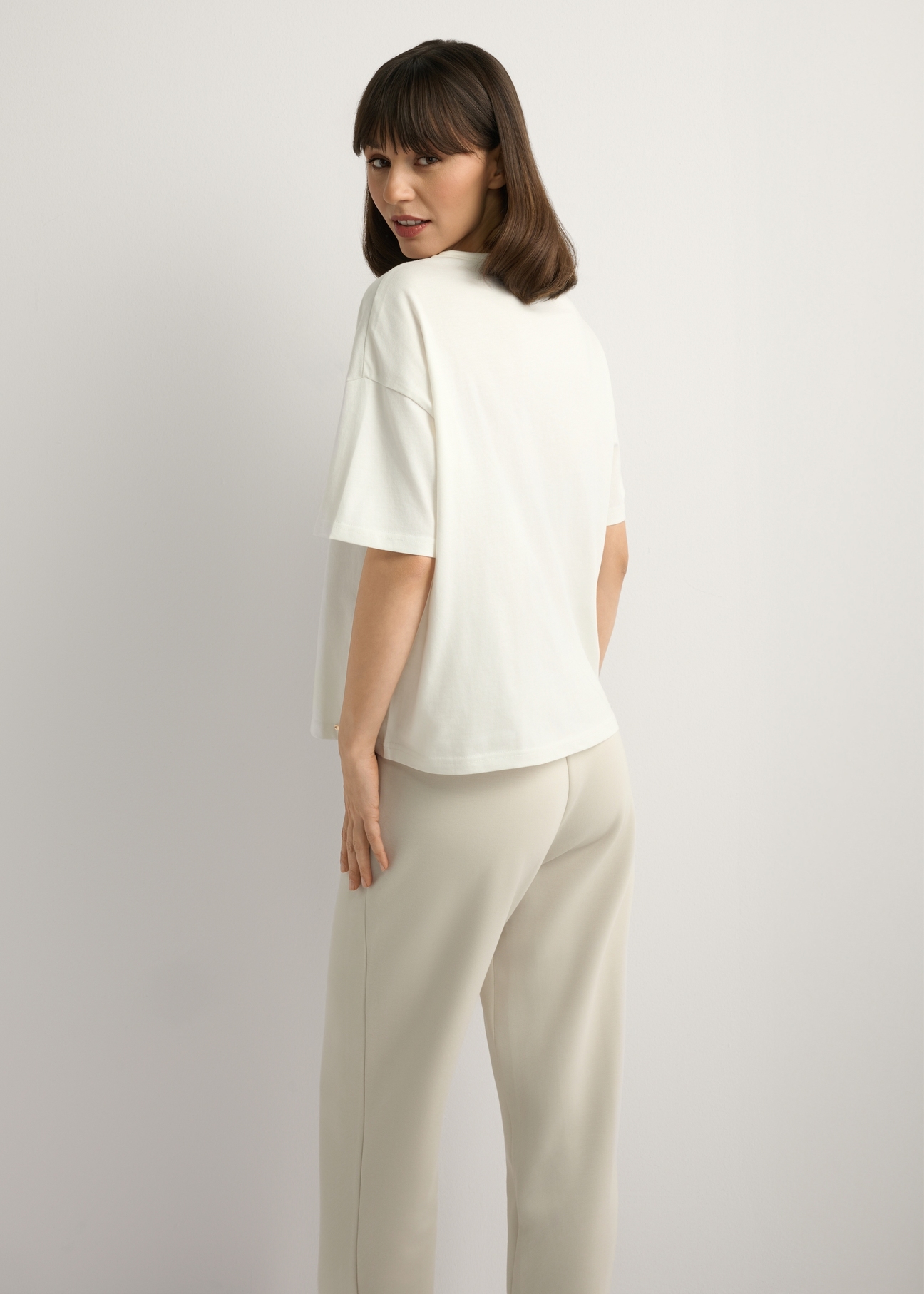 Cream women's T-shirt with print TSHDT-0161-0B(W26), back view of the product on the model. Half of the silhouette visible.