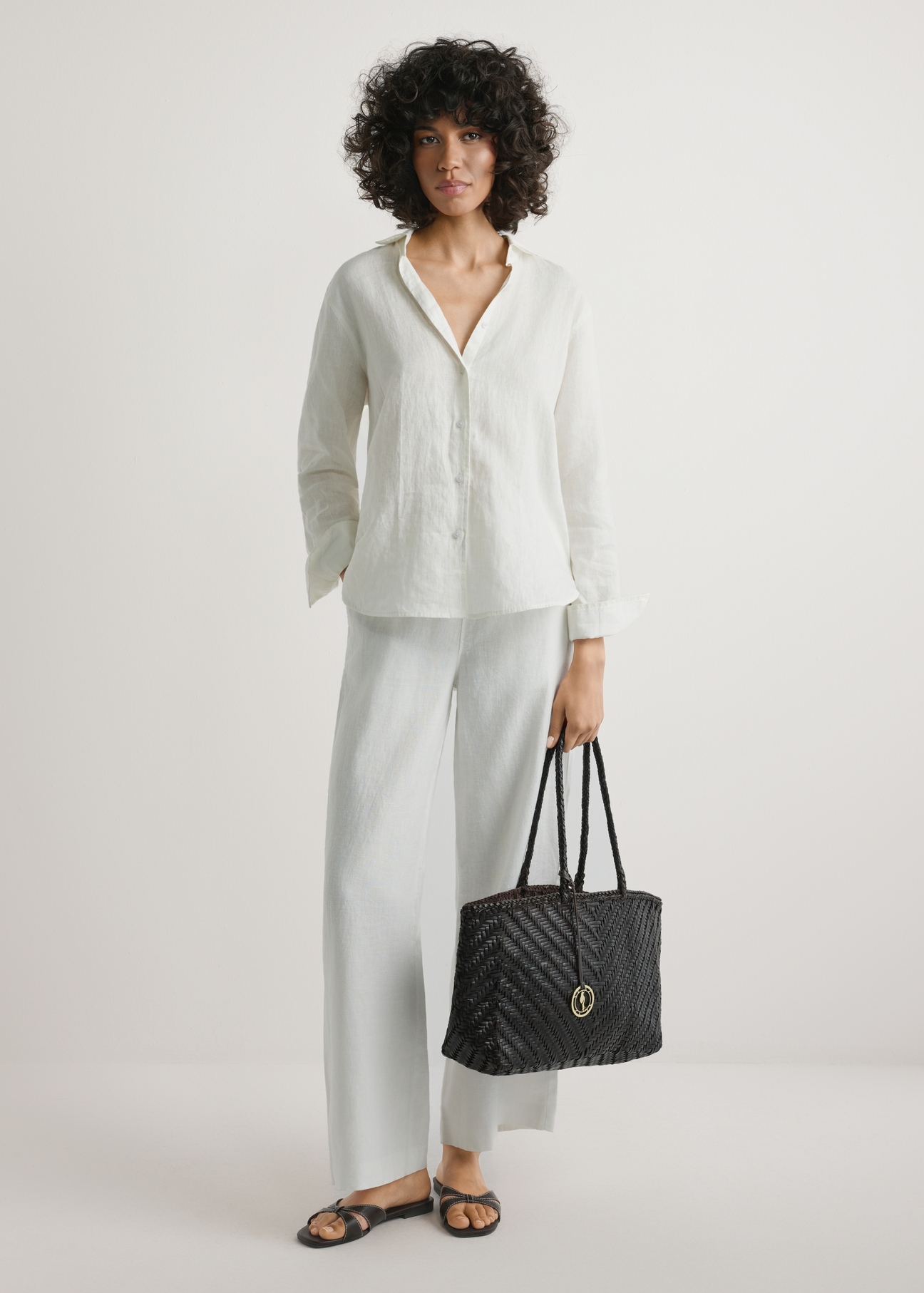 Dark brown woven women's handbag TORES-1301-1I(W26), product view in model's hand. Full body visible.