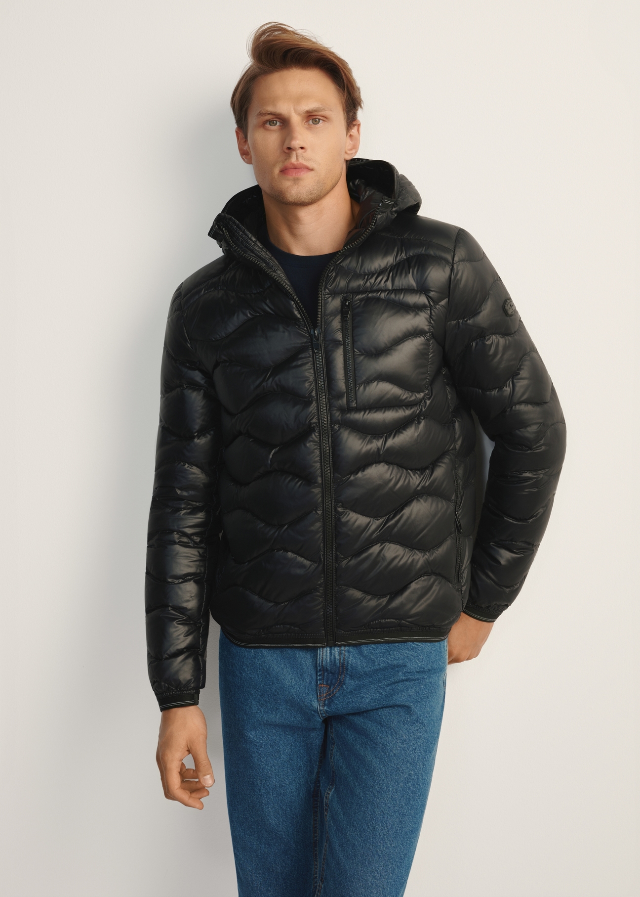 Men's black quilted jacket KURMT-0400-99(Z25), front product view on model. Half silhouette visible.
