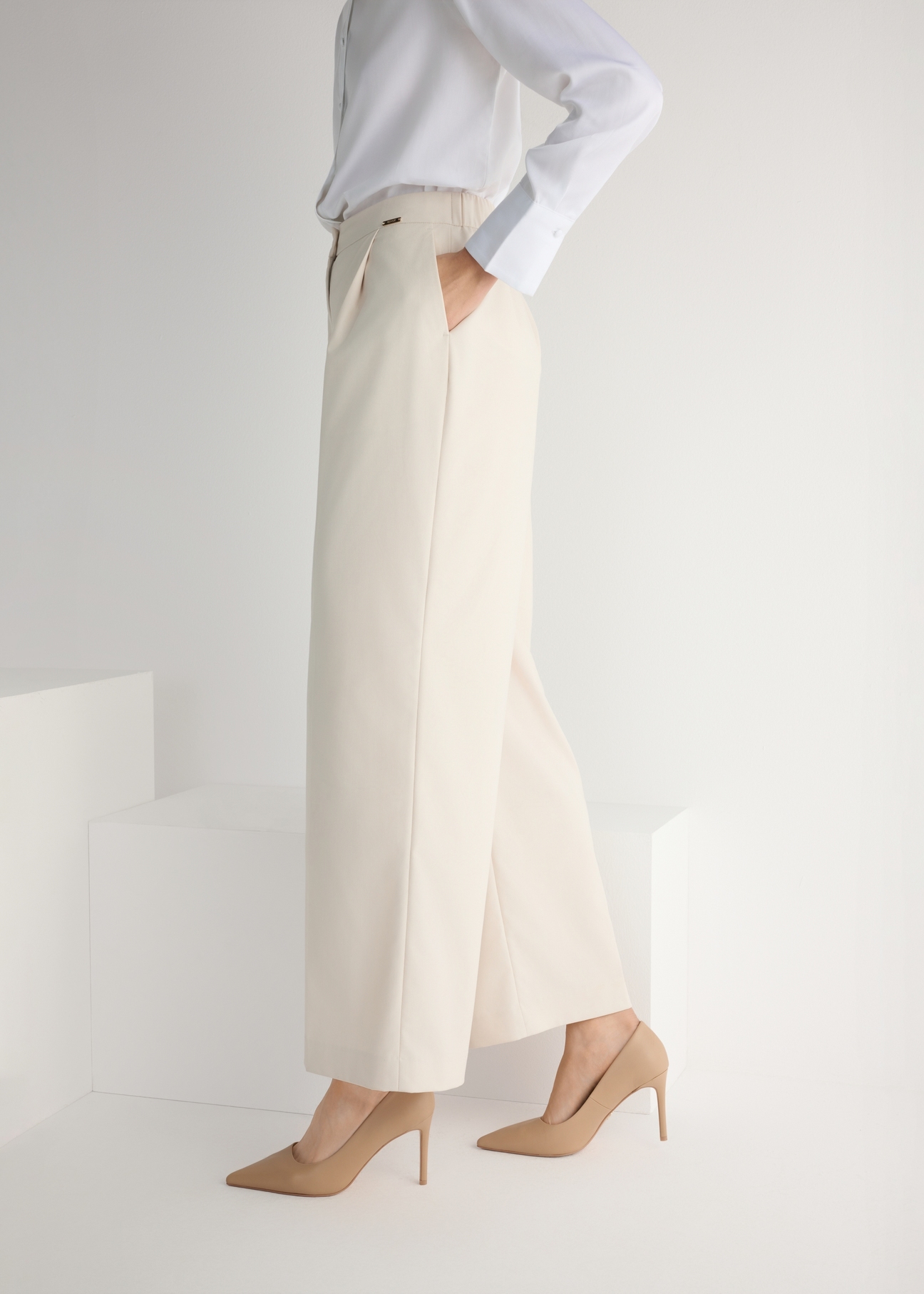 Beige leather women's high heels BUTYD-1131A-1B(W26), side view of the product on the model, half of the silhouette visible.