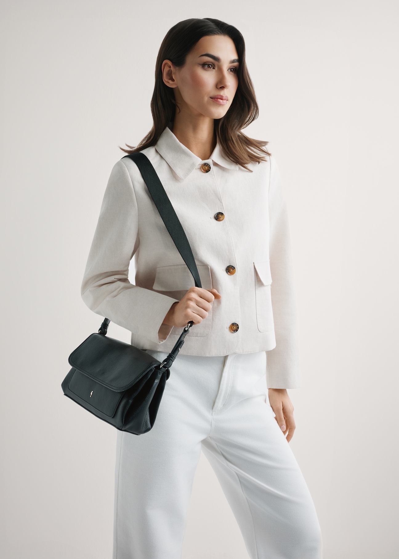 Classic black women's handbag TOREC-1124-99(W26), product view on model's shoulder. Half of silhouette visible.