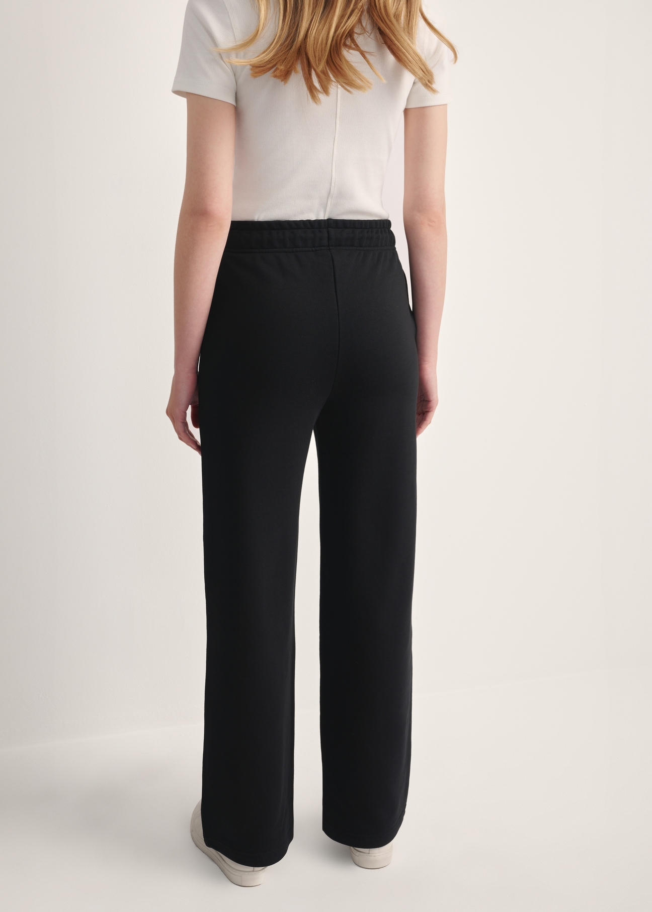 Black women's trousers SPODT-0111-99(Z25), back view of the product on the model. Half of the silhouette visible.