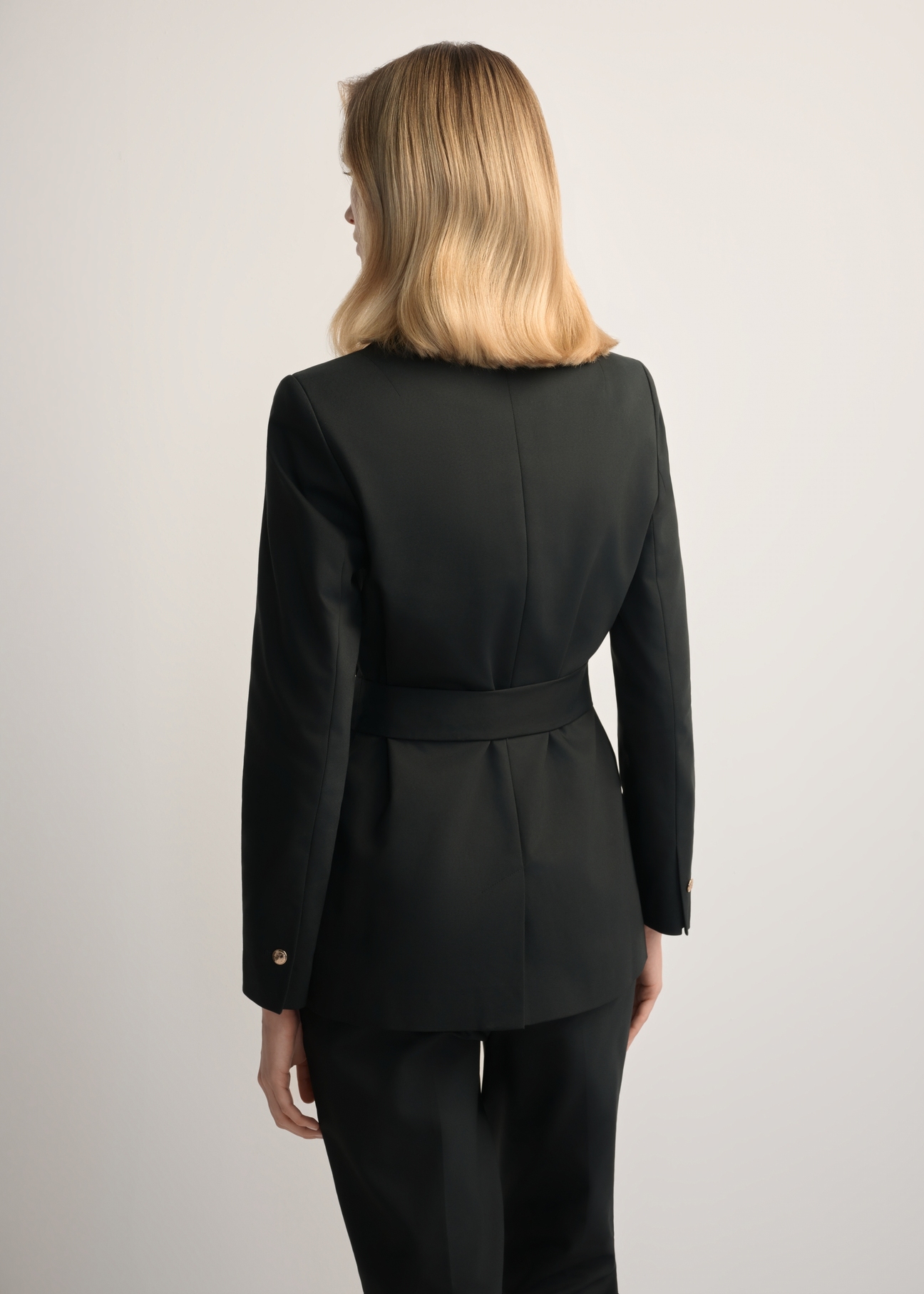 Women's black belted blazer ZAKDT-0030-99(W25), back view of the product on the model. Half of the silhouette visible.