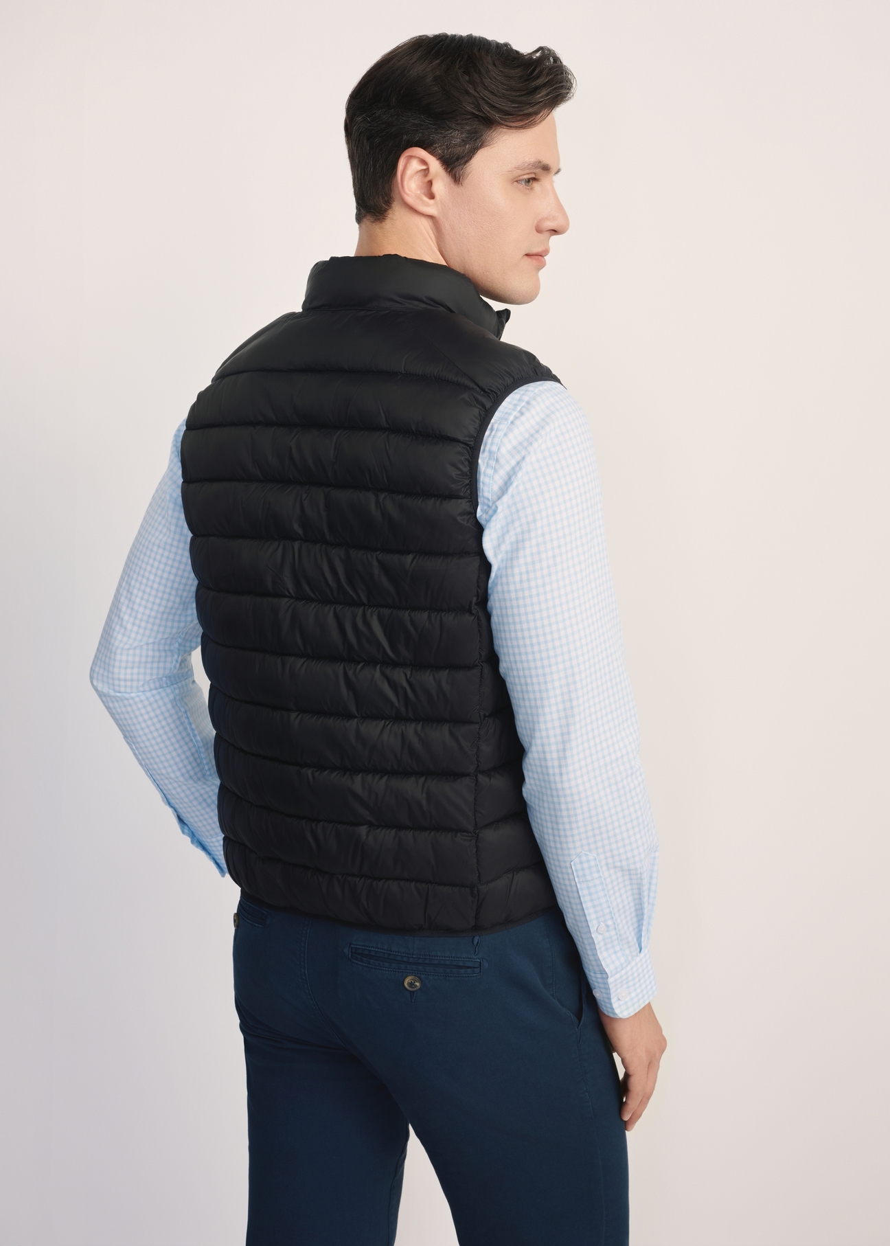 Black quilted men's vest KAMMT-0006-99(Z25), product view from the back on the model. Half of the silhouette visible.